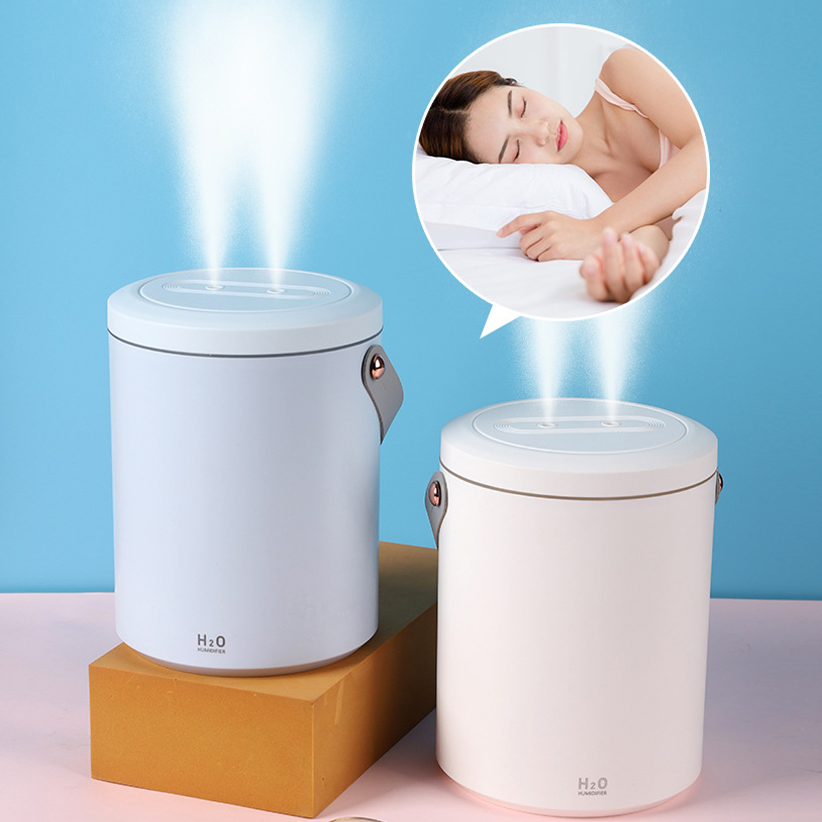 Zwei weiße und hellblaue Luftbefeuchter. Im Hintergrund schläft eine Frau. H2O Humidifier vorne.