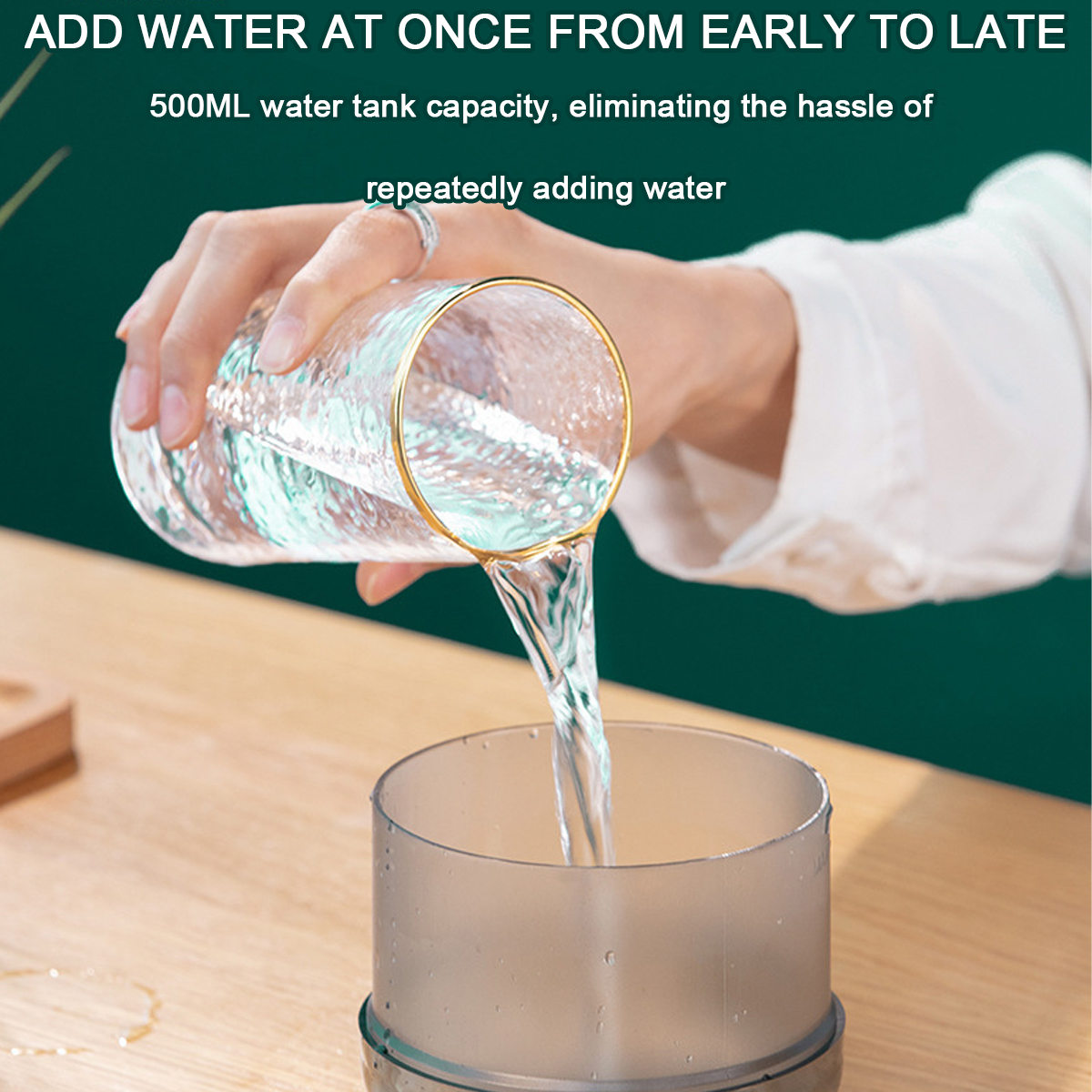 Person gießt Wasser in einen grauen Luftbefeuchter, mit einem Glas mit Goldrand.
