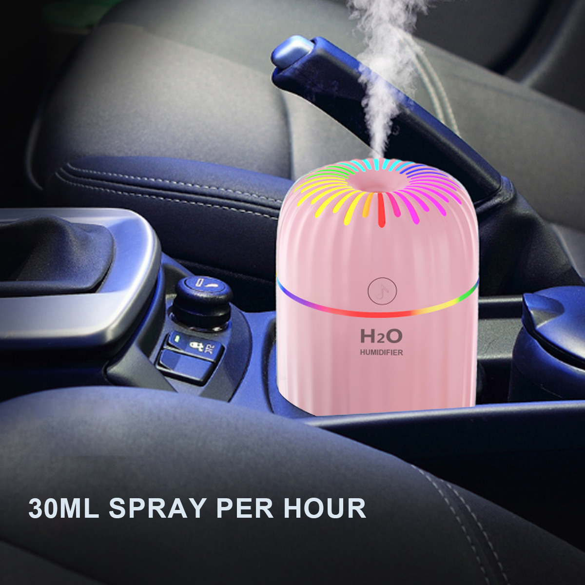 Ein rosa Luftbefeuchter mit Regenbogenlichtring in einem Auto. Verströmt Dampf, H2O-Text.