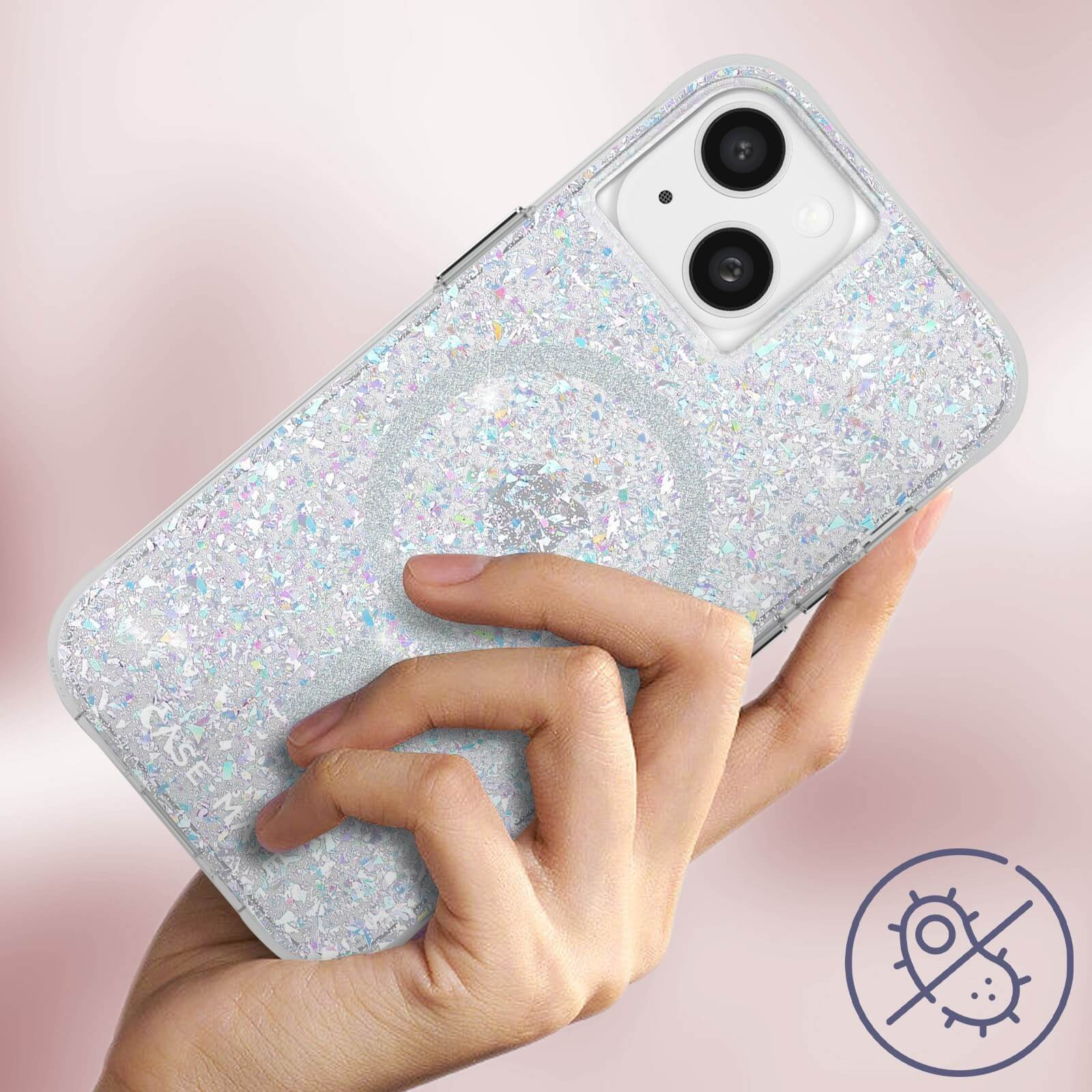 Eine Handyhülle mit Glitzer und einem silbernen Kreis. Sie wird gehalten, mit einem Keimschutzsymbol.