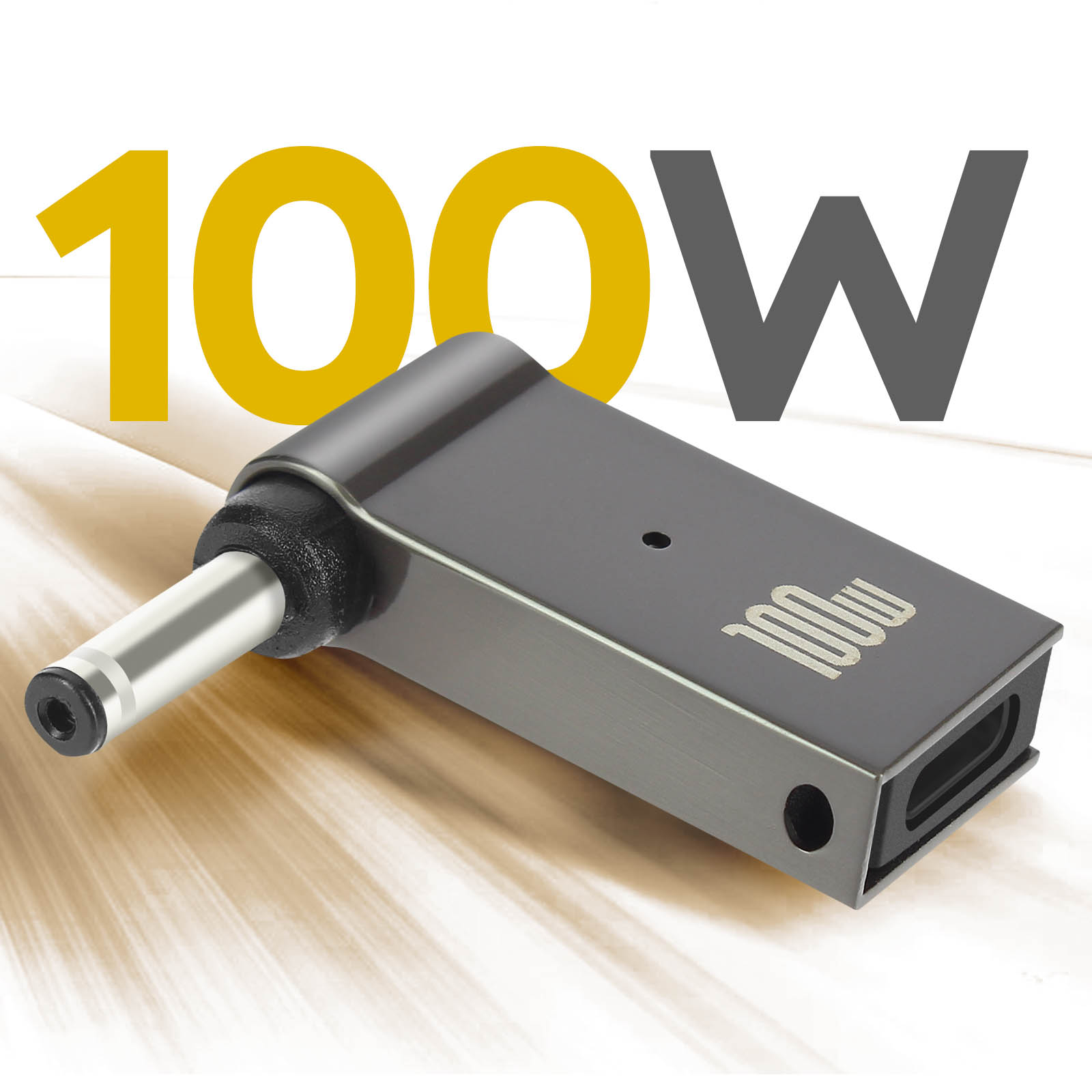 Adattatore di alimentazione nero con testo 100W. Spina argentata. Sfondo giallo e grigio.
