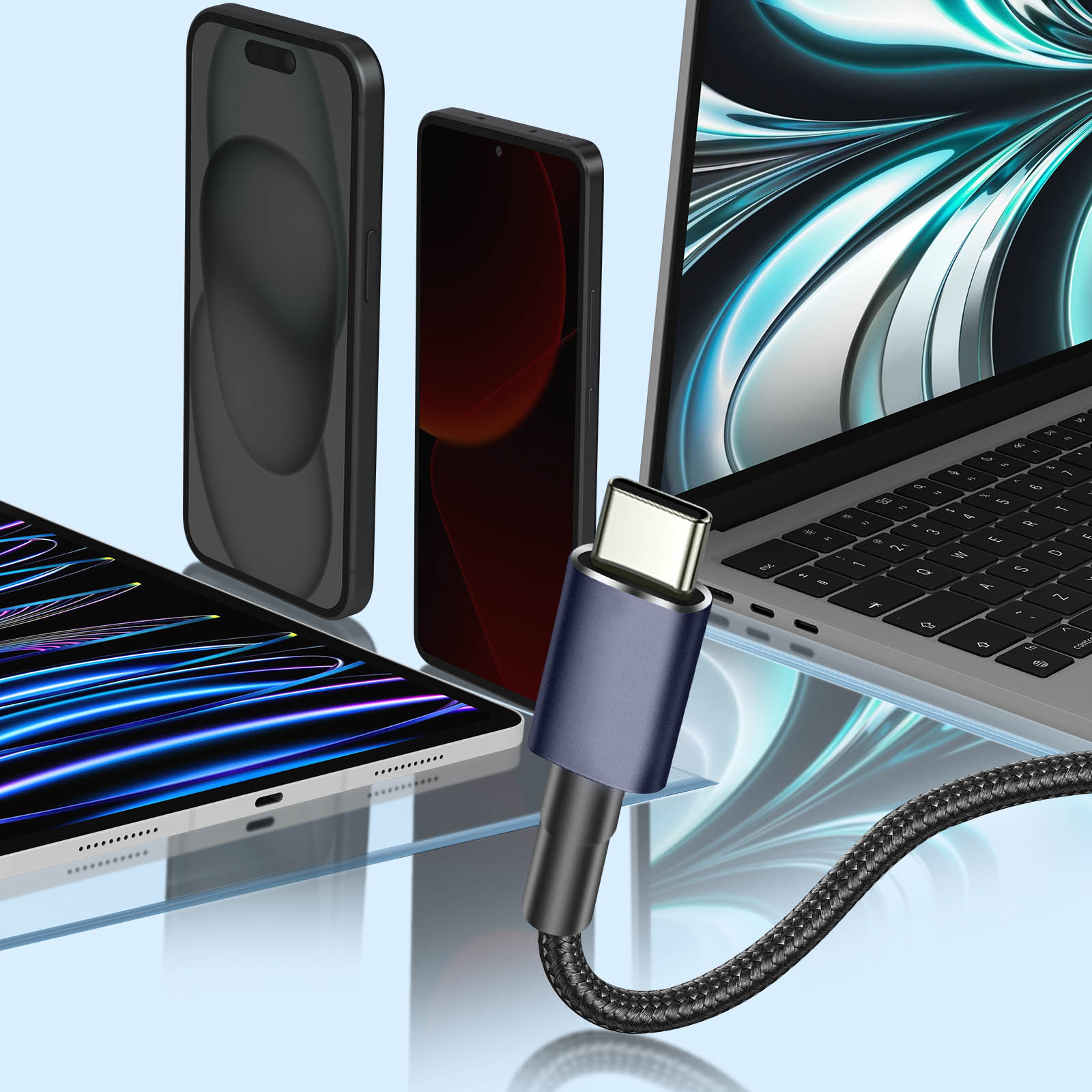 Un cavo USB-C collegato a un laptop, con due telefoni e un tablet sullo sfondo.