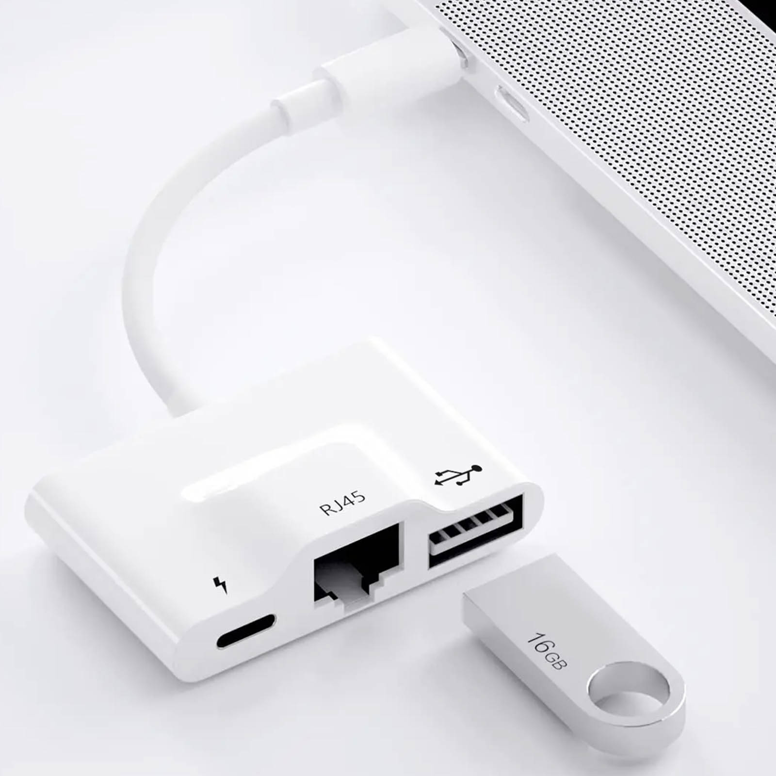 Un adattatore bianco con porte RJ45, USB e USB-C collegato a un laptop e a un'unità flash da 16GB.
