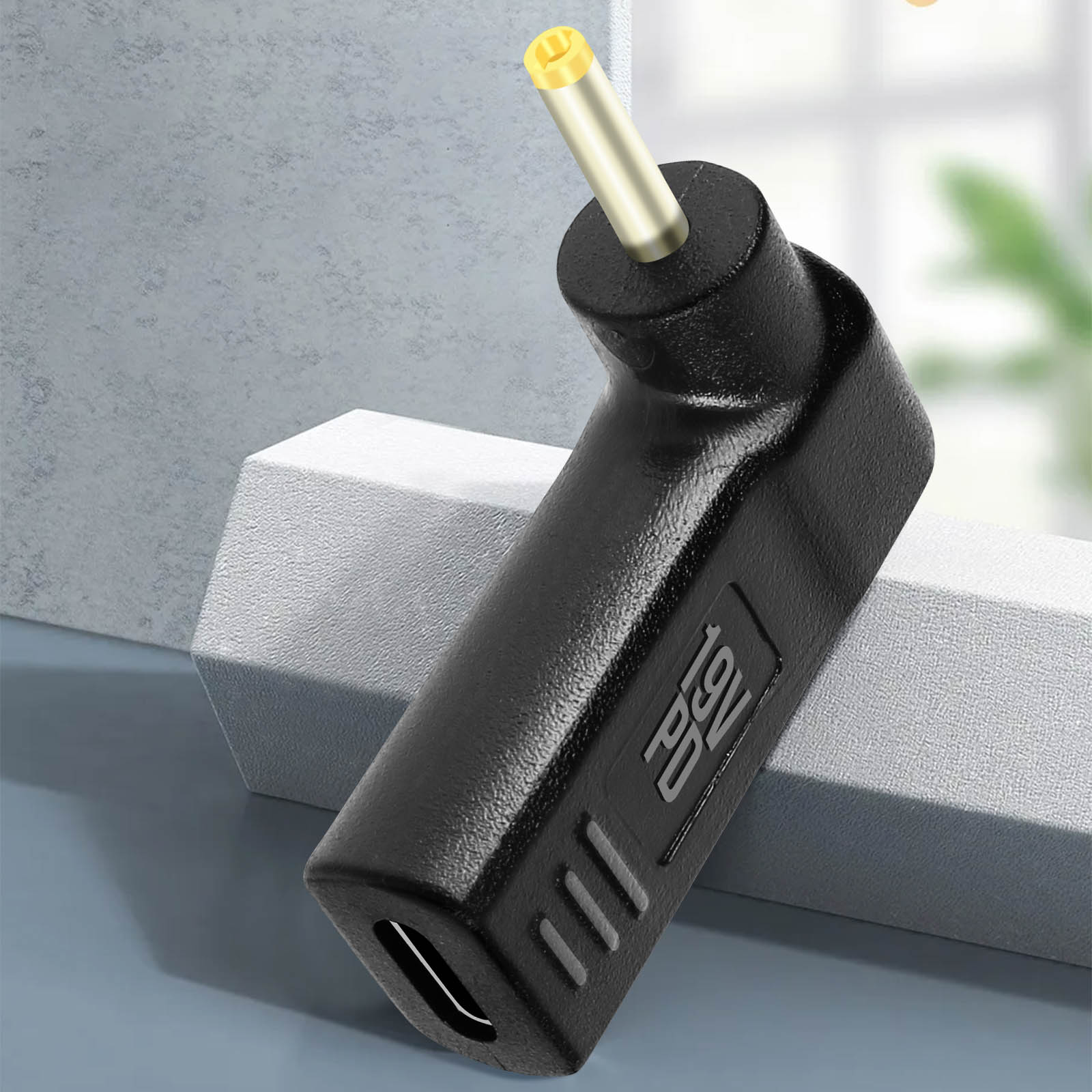 Adattatore di alimentazione CC ad angolo retto nero. L'ingresso è USB-C, l'uscita è un connettore a barilotto con punta gialla.