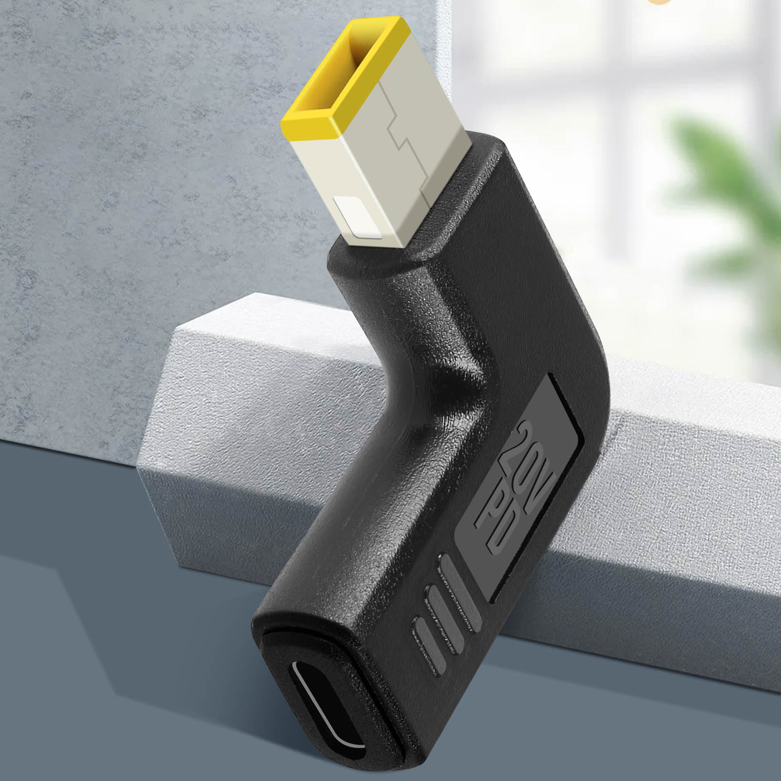Adattatore per laptop nero con connettore giallo e bianco. L'adattatore è angolato e ha una porta USB-C.