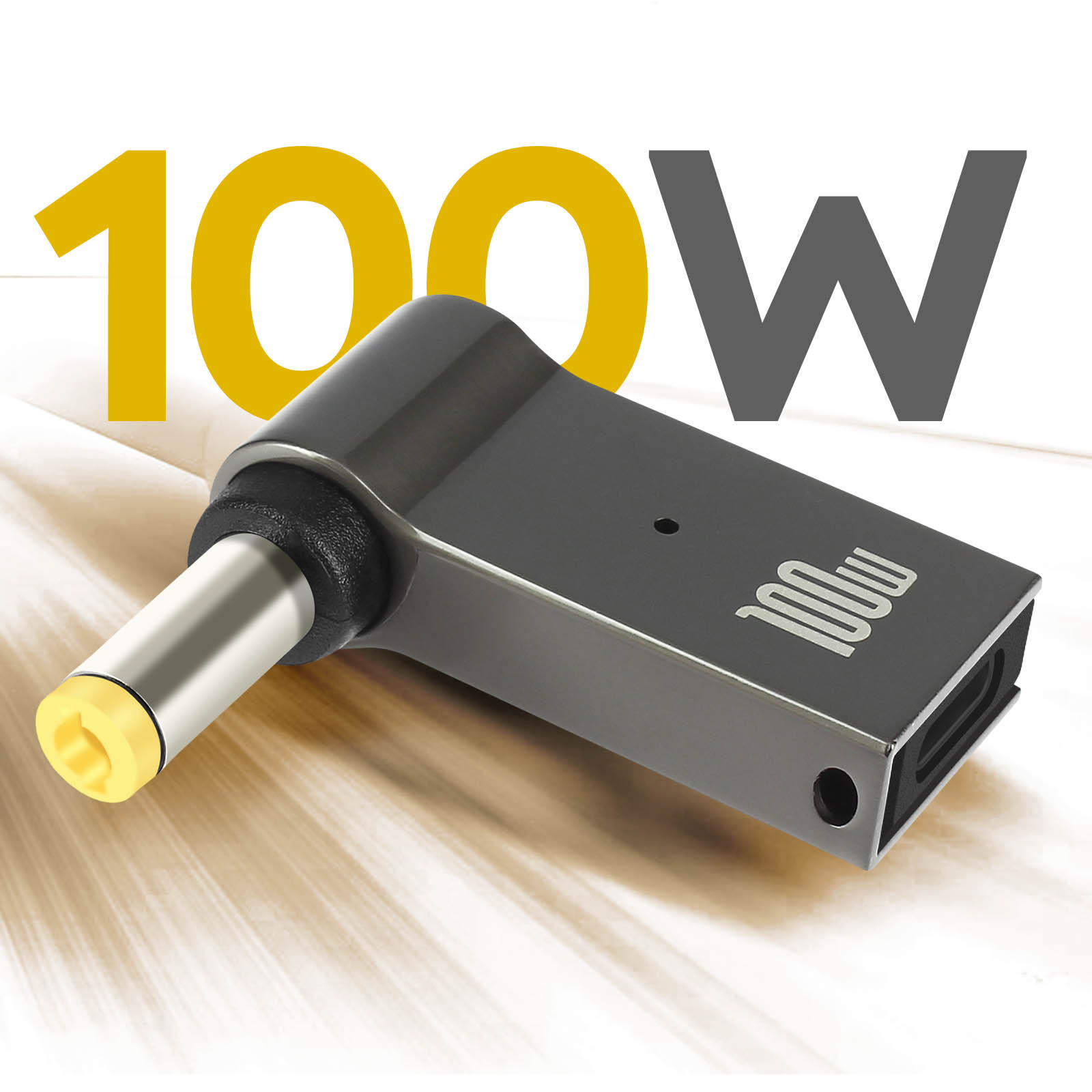 Un caricatore grigio scuro da 100W con punta gialla. Il caricatore ha una porta laterale e un marchio da 100W.