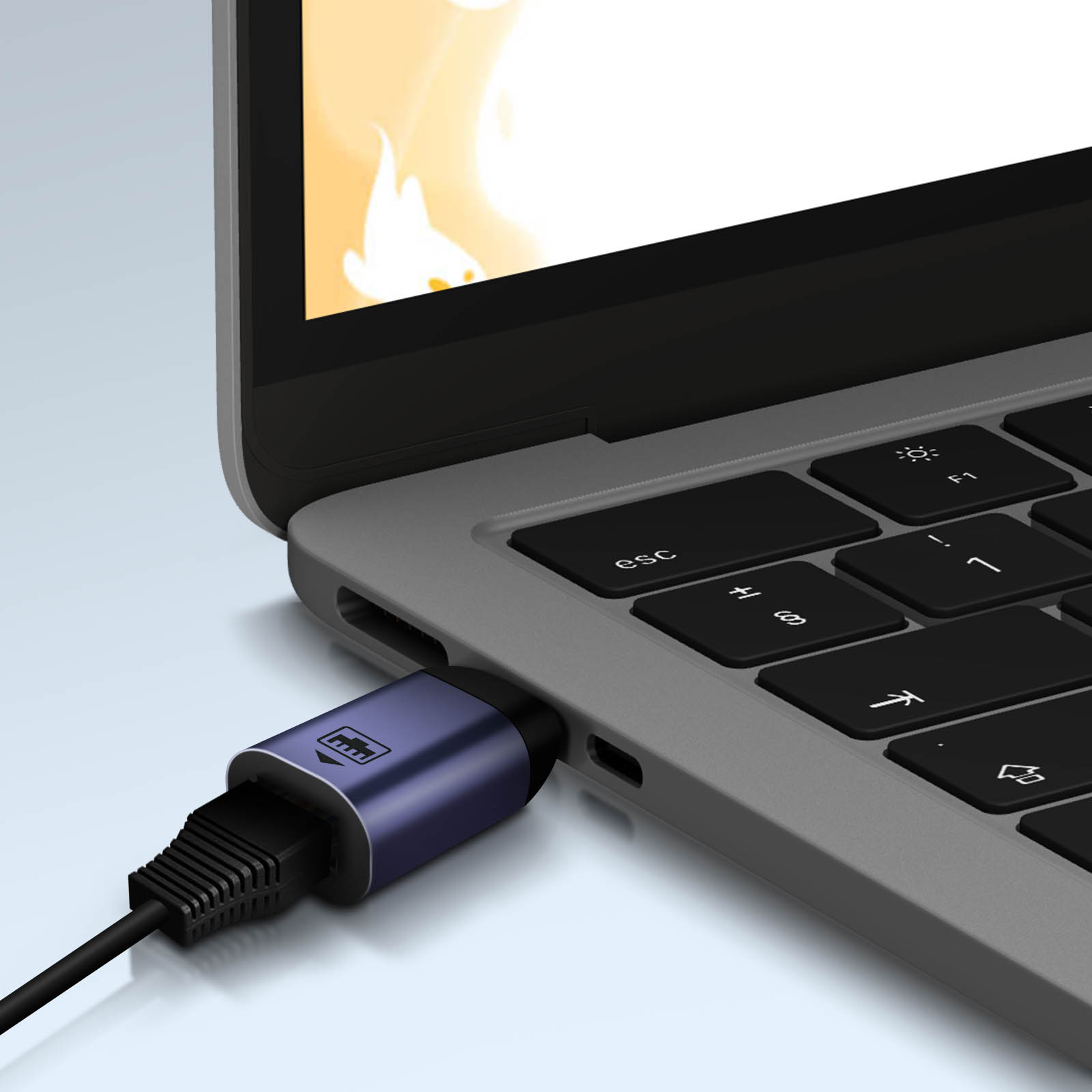 Laptop collegato a un adattatore blu, con cavo nero inserito.