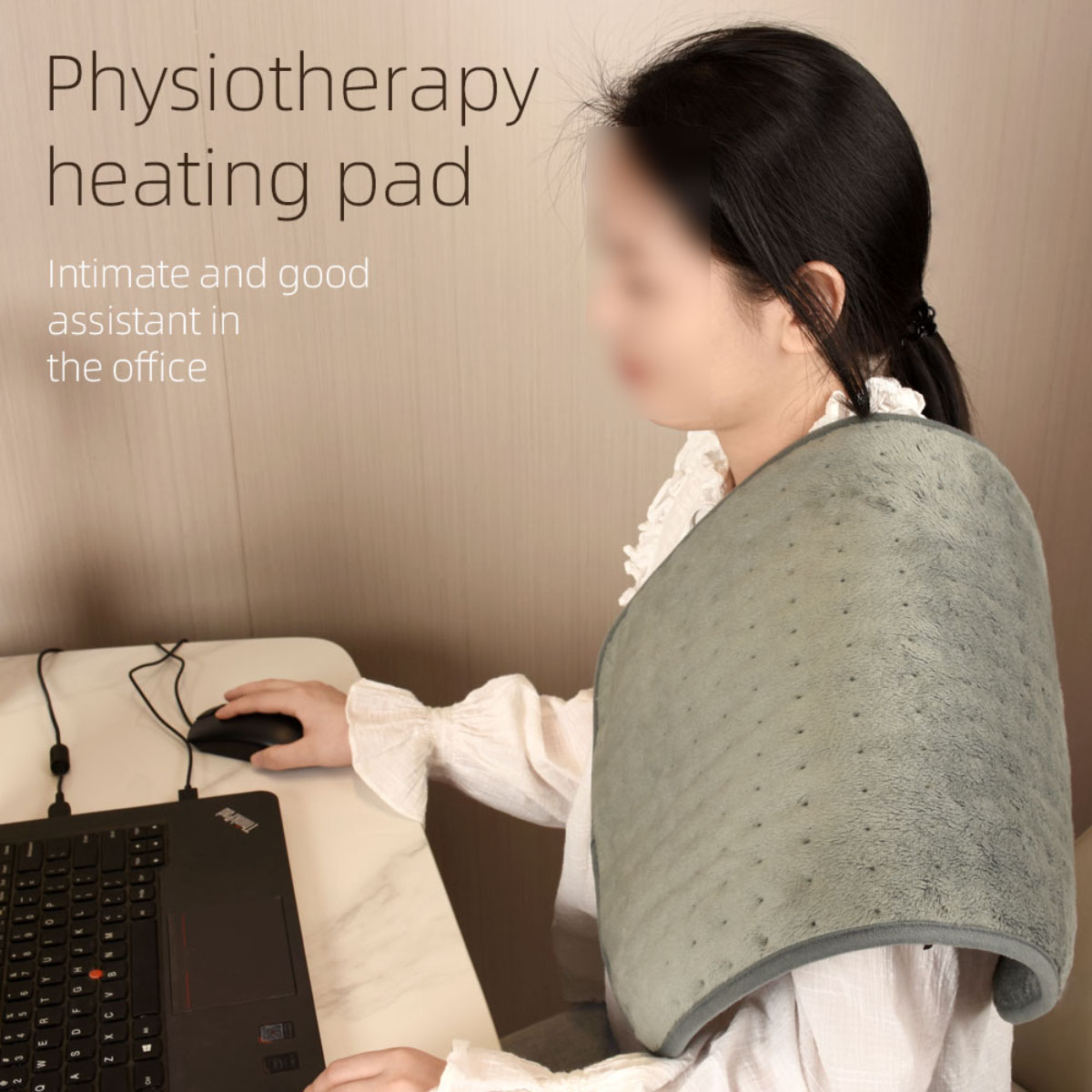 Frau mit einem grauen Physiotherapie-Heizkissen auf der Schulter, die Laptop und Maus am Schreibtisch benutzt.