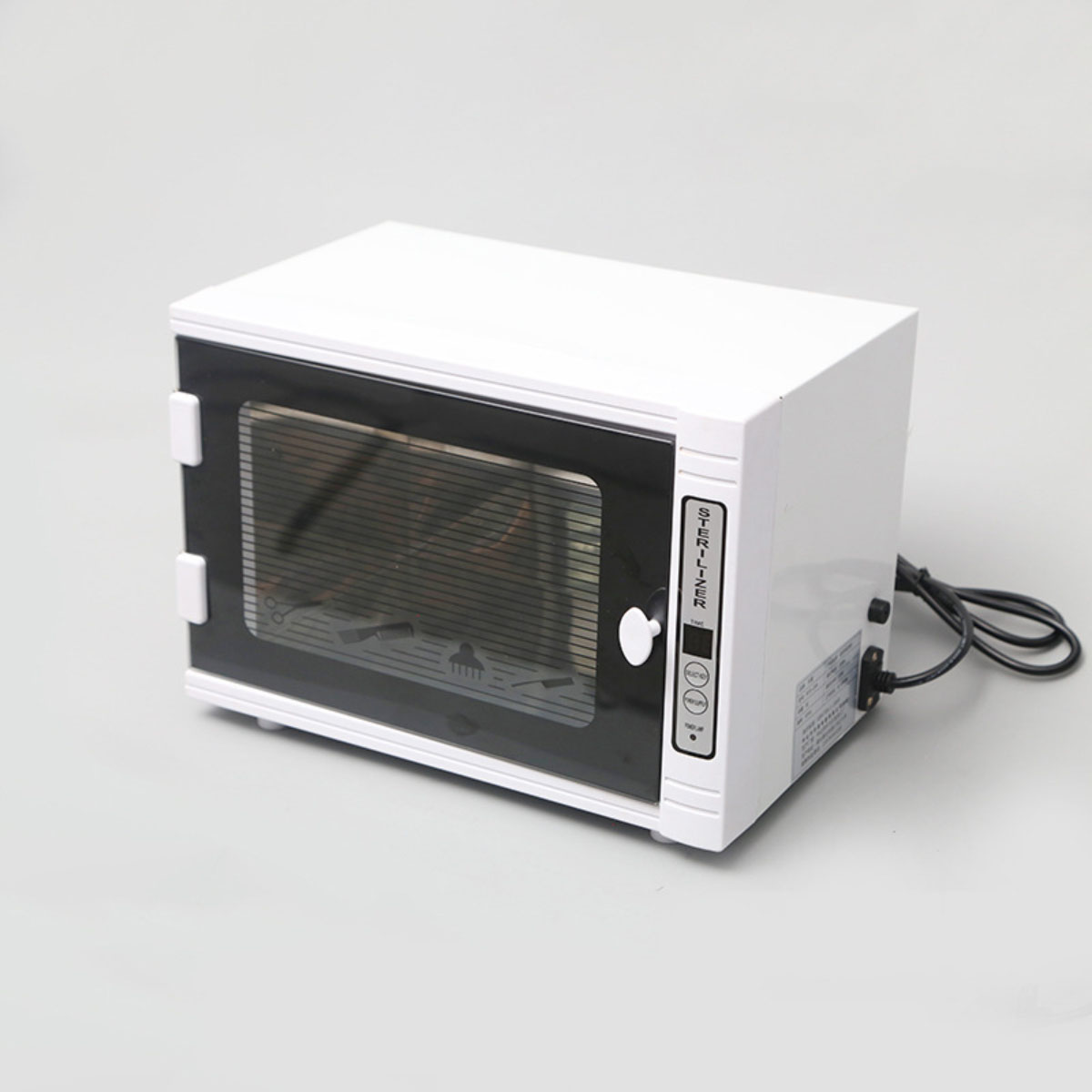 Esterilizador blanco y cerrado con puerta de cristal y panel de control.
