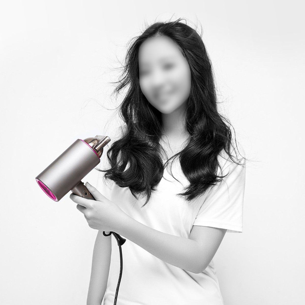 Mujer sosteniendo secador de pelo. Cabello borroso, rostro oscurecido, fondo blanco.