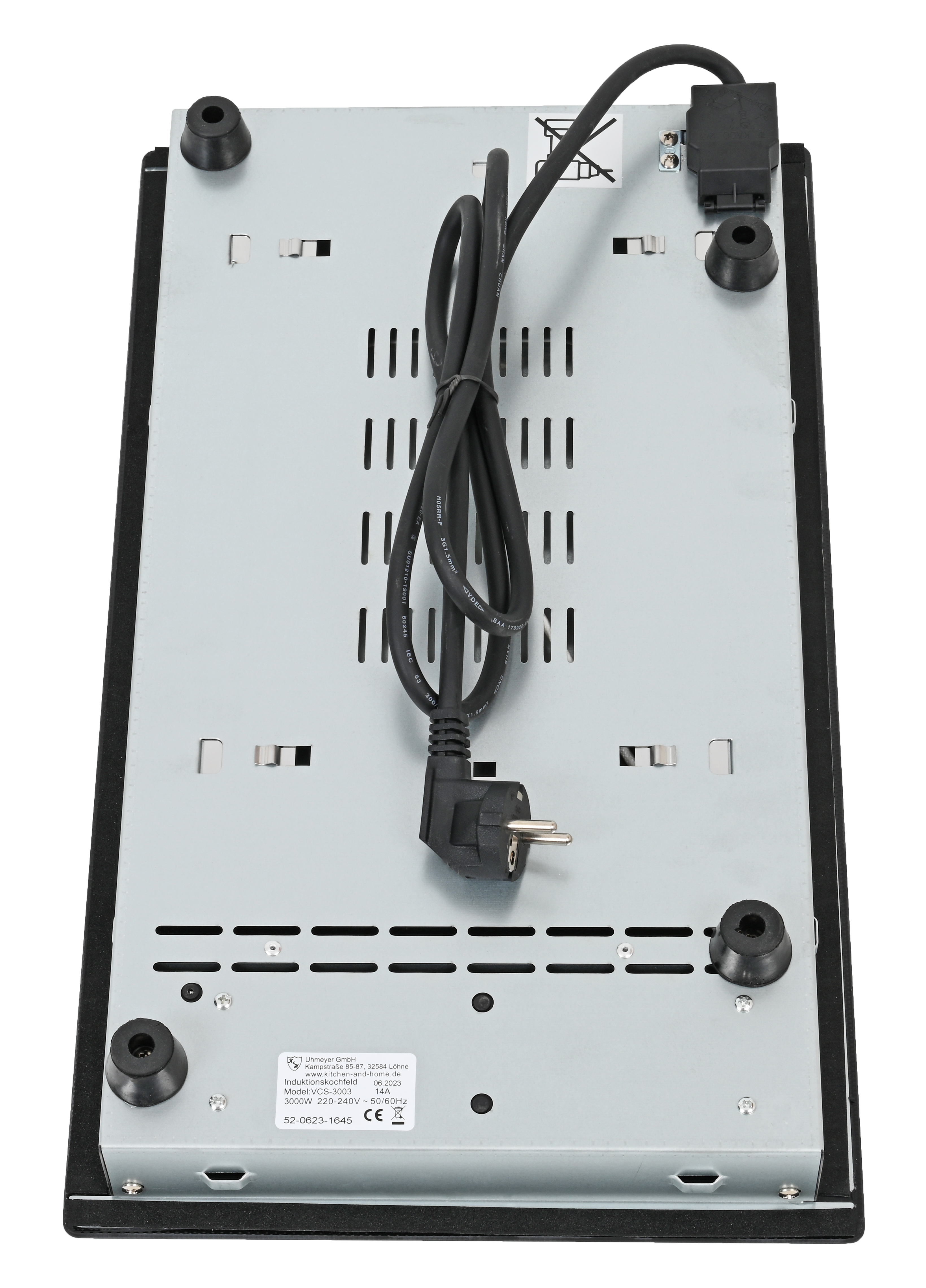 Die Unterseite eines Induktionskochfelds mit Netzkabel und vier schwarzen Füßen. Es ist auf einer weißen Oberfläche.