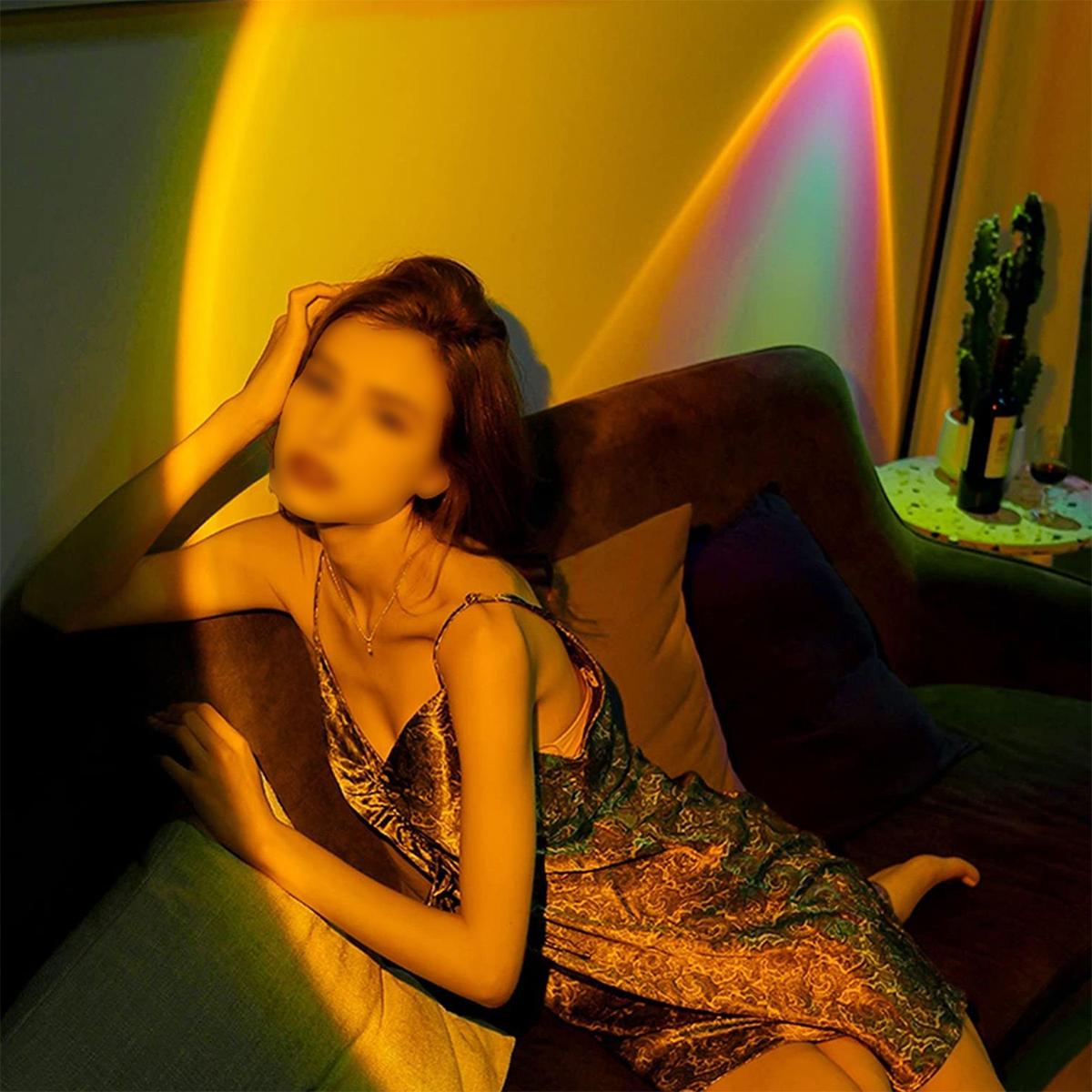 Mujer en un sofá en una habitación con iluminación colorida. La iluminación brilla sobre la mujer.
