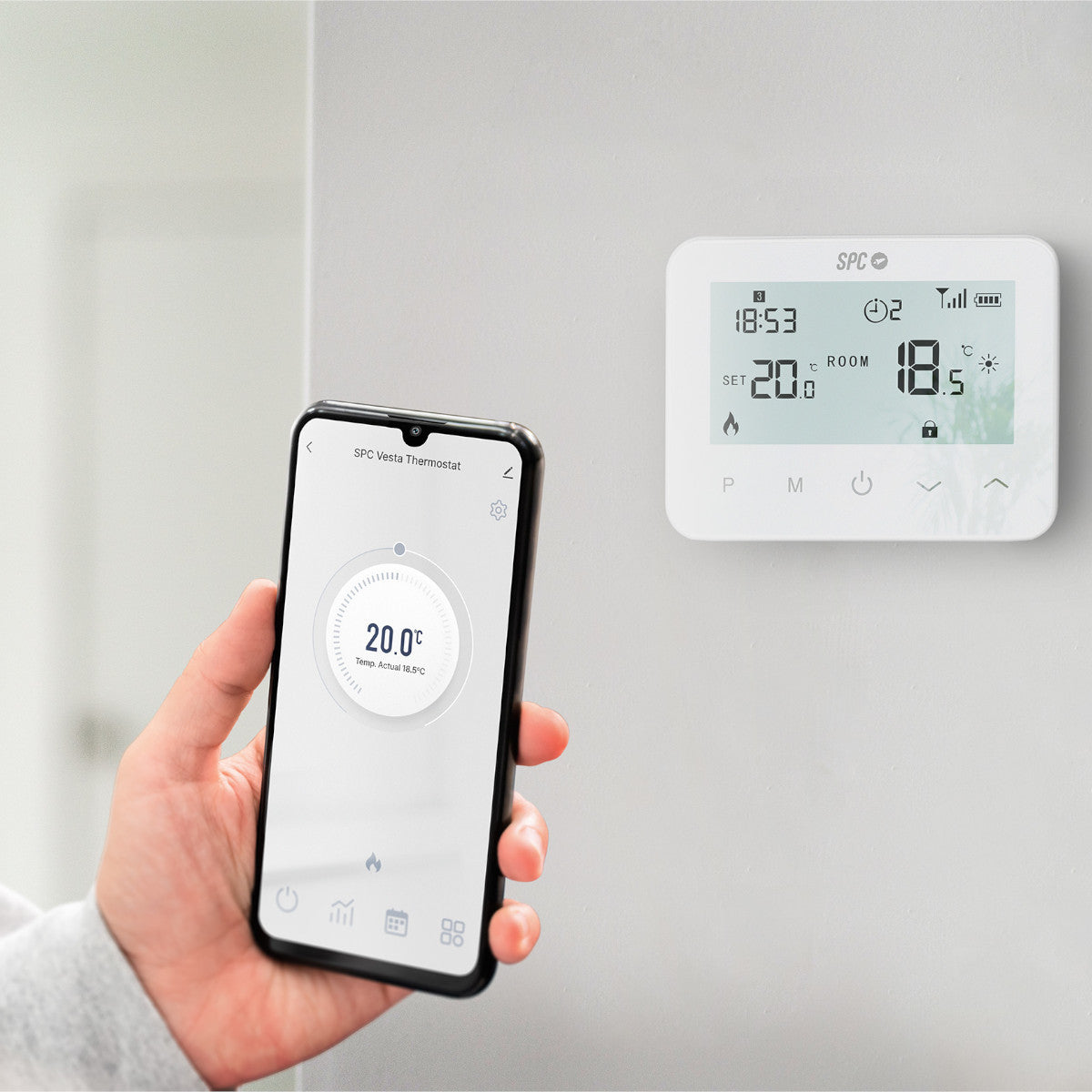 Mano sosteniendo un smartphone que muestra controles de termostato cerca de un dispositivo montado en la pared.
