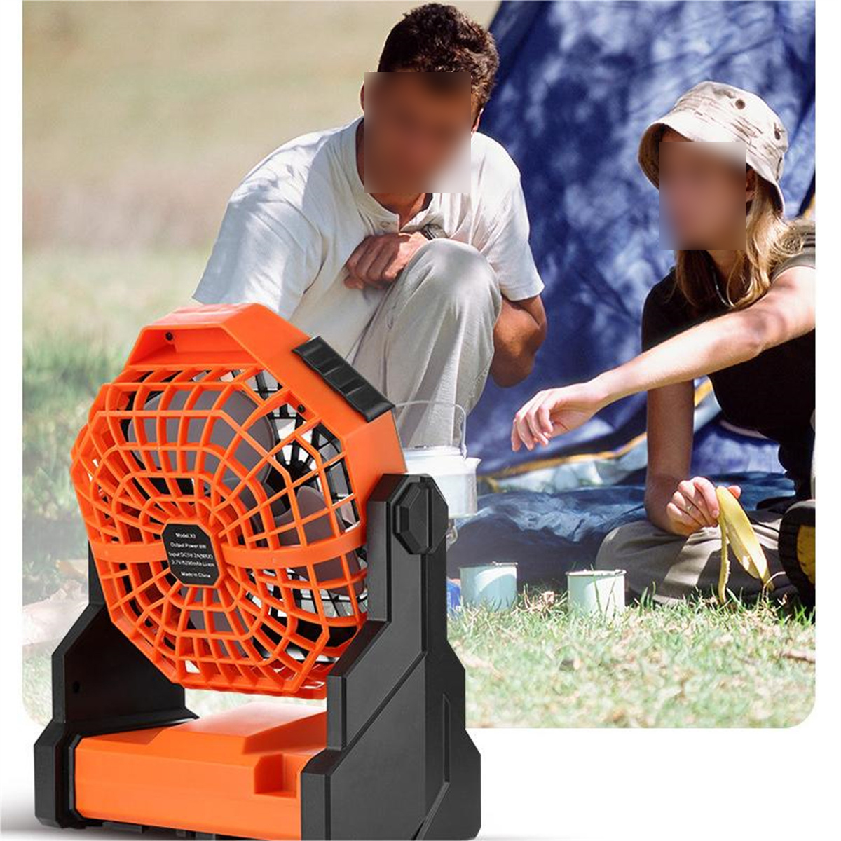 Orangener und schwarzer tragbarer Ventilator, zwei Personen und ein Zelt im Freien.