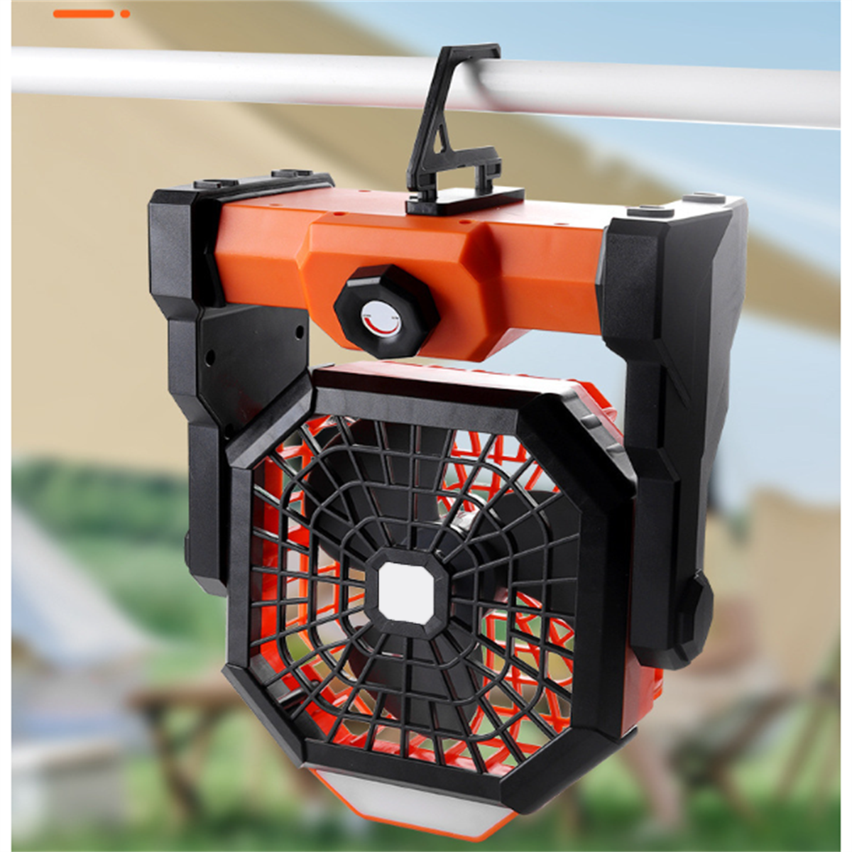 Orange-schwarzer Campingventilator mit Tragegriff. Hintergrund ist ein Zelt.
