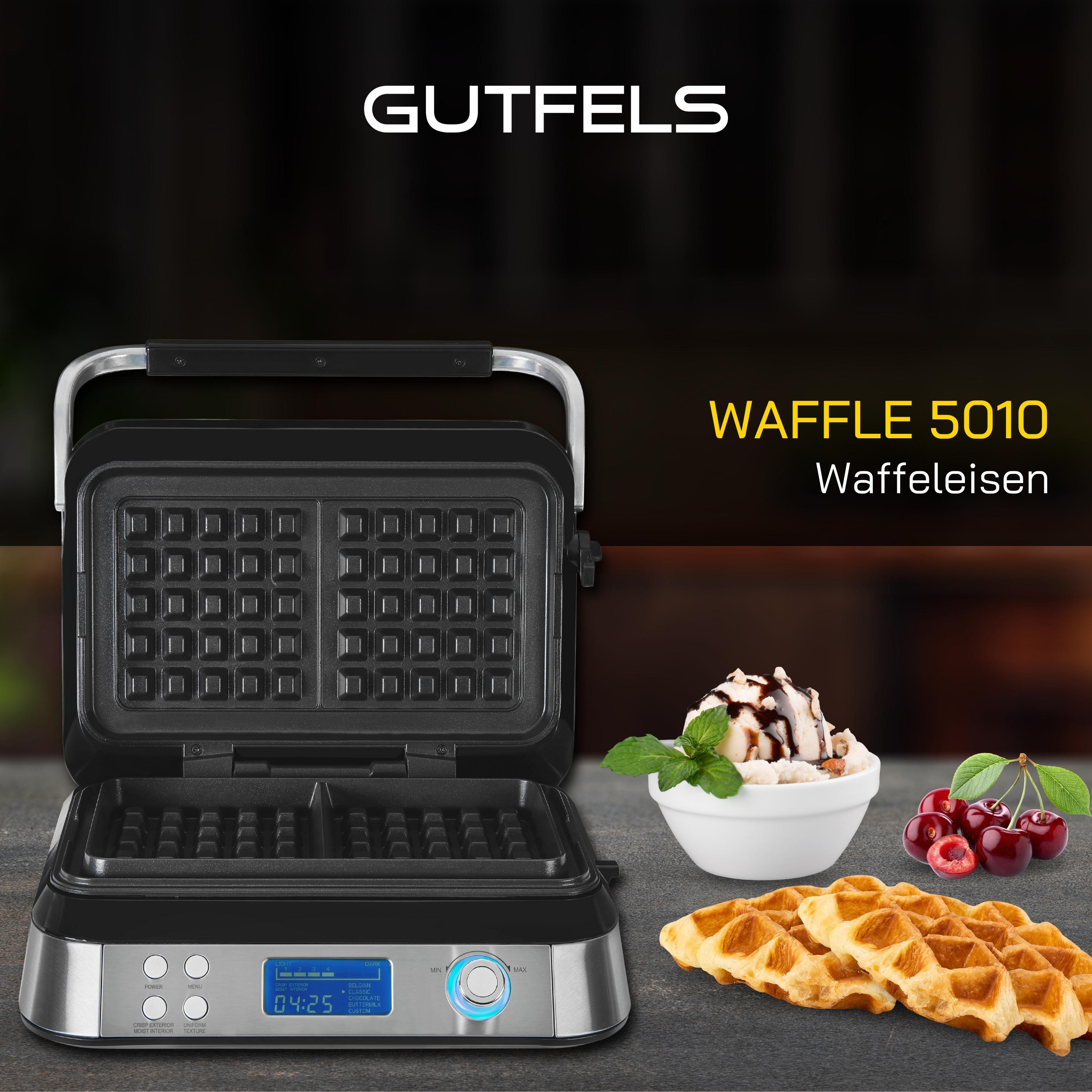 Schwarzer Waffeleisen mit Waffeln, Kirschen und einer Schüssel Eis. Die Maschine hat ein Display.