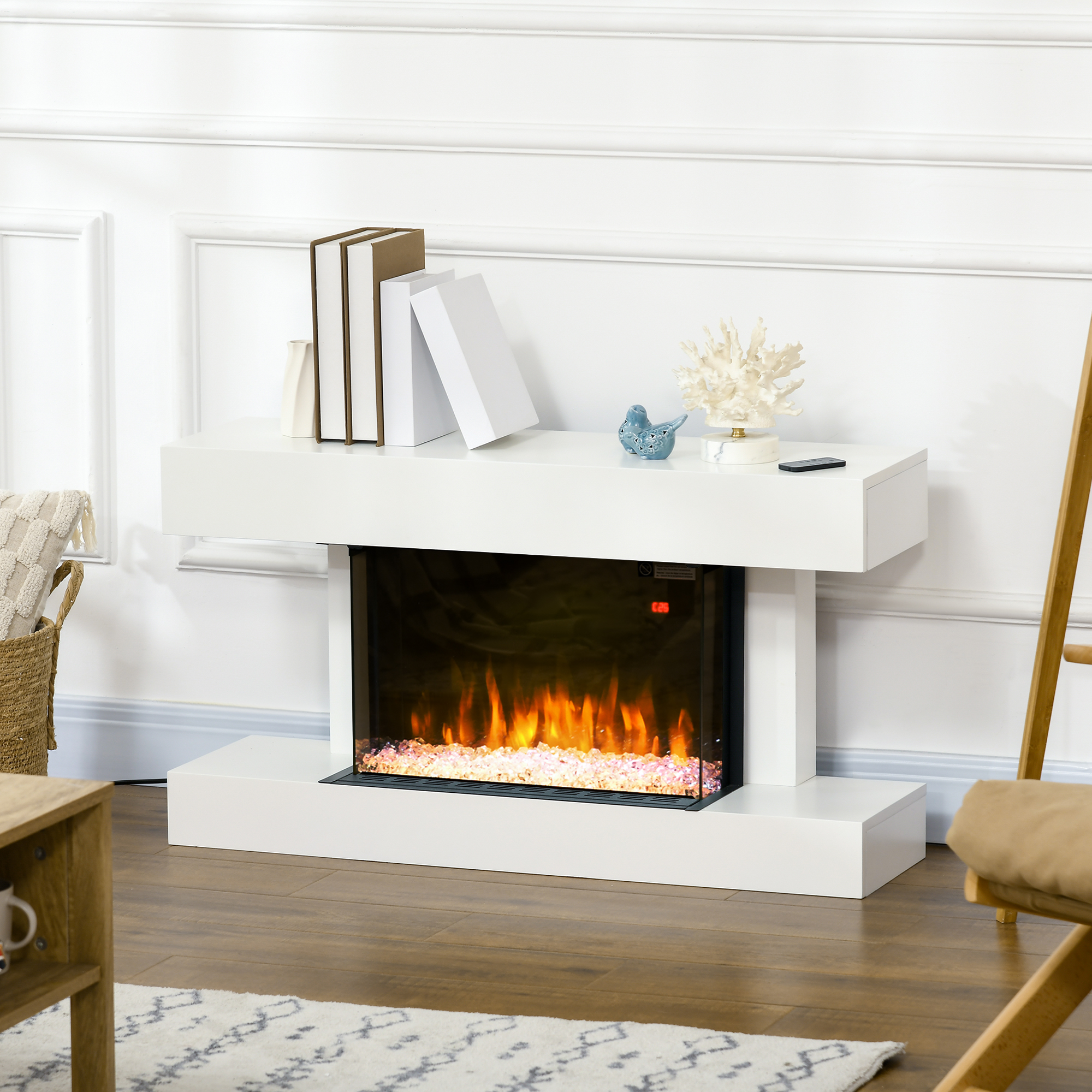 Chimenea blanca con efecto de fuego brillante y libros encima. Un pájaro azul está colocado encima.