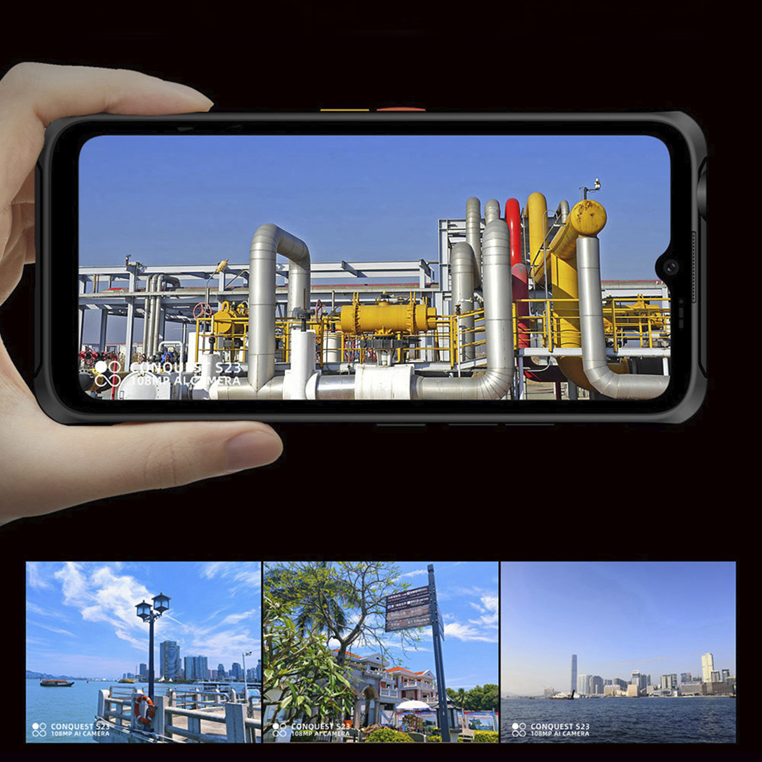Mano che tiene un telefono nero che mostra una scena industriale e tre scene più piccole sotto.