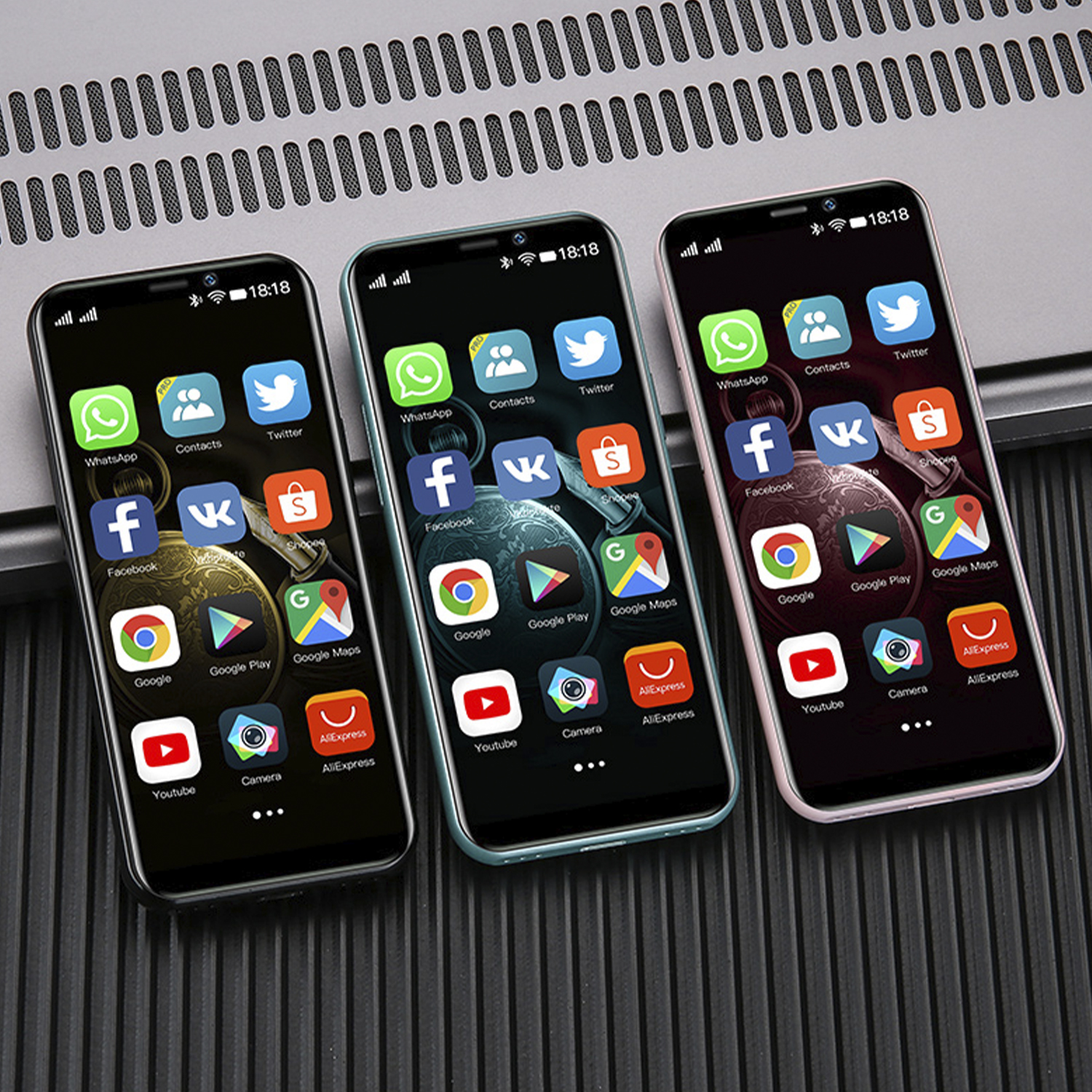 Drei Smartphones mit Apps auf den Bildschirmen. Sie befinden sich auf einer dunklen Oberfläche.