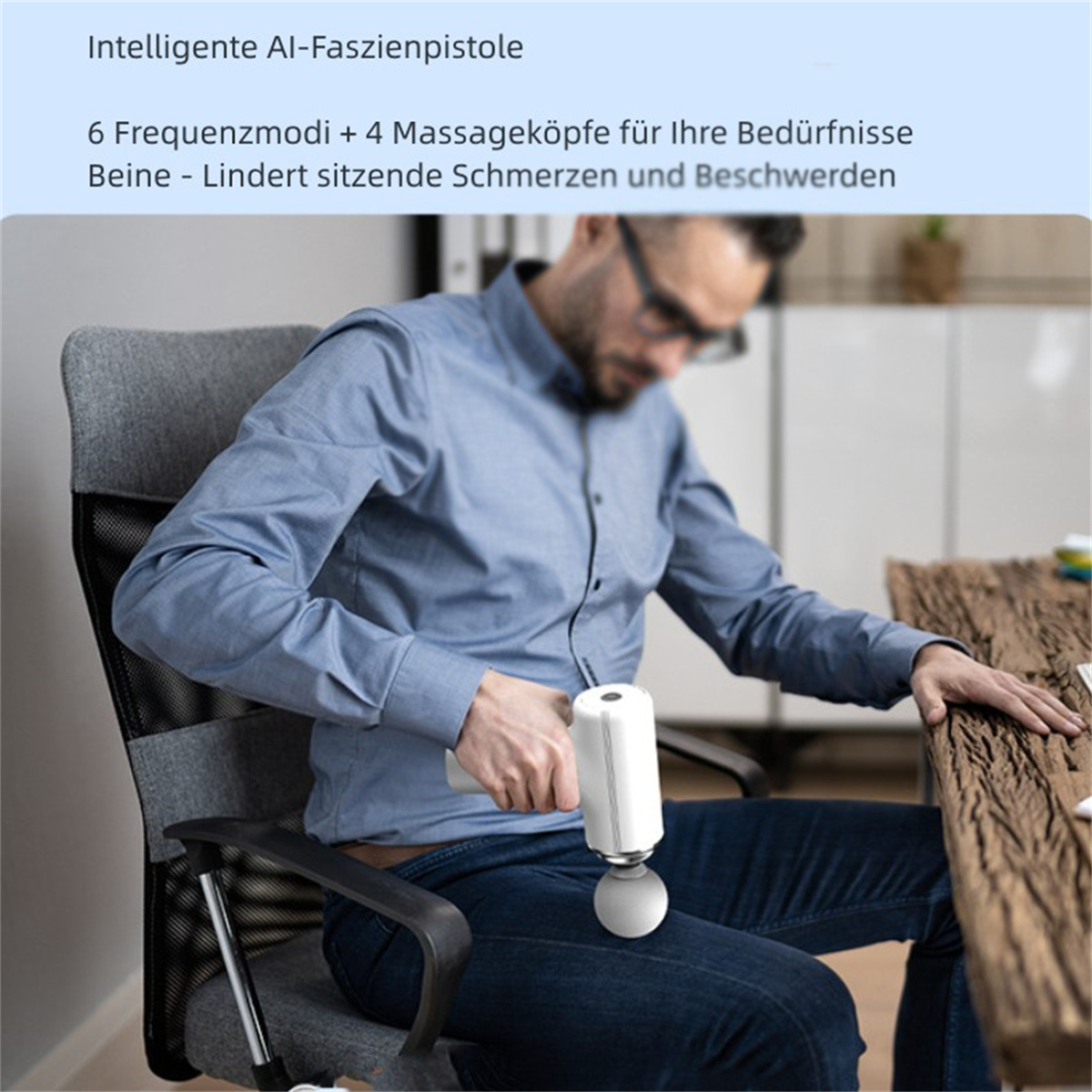 Mann sitzt und benutzt eine Massagepistole an seinem Bein. Grauer Stuhl, Holzschreibtisch. Weiße Pistole.