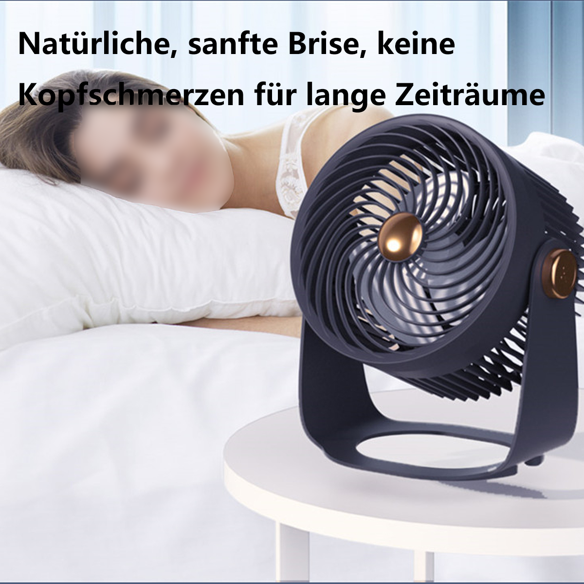 Ein Ventilator auf einem Tisch mit einer schlafenden Frau im Hintergrund. Der Ventilator ist dunkelblau.