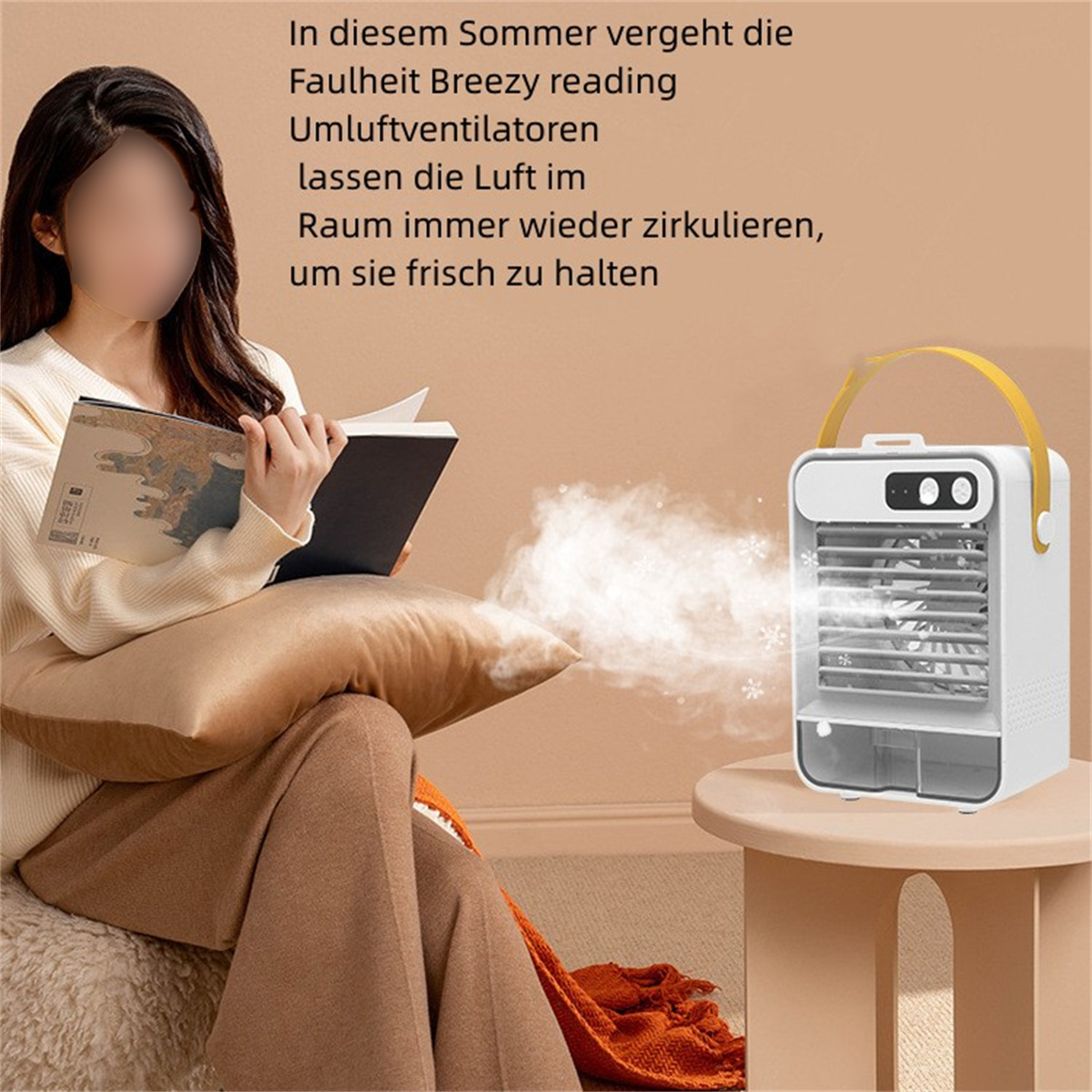 Una mujer lee un libro cerca de un enfriador de aire blanco. El enfriador está sobre una mesita y expele niebla.