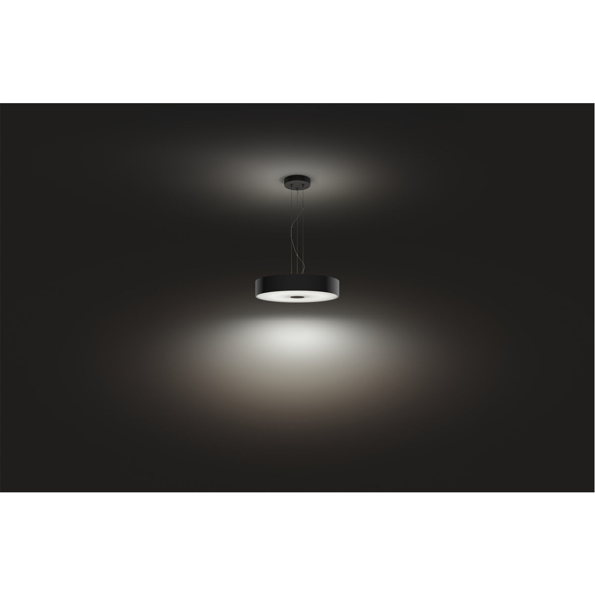 Un luminaire suspendu circulaire noir est suspendu sur un fond gris foncé, avec une lueur vive en dessous.