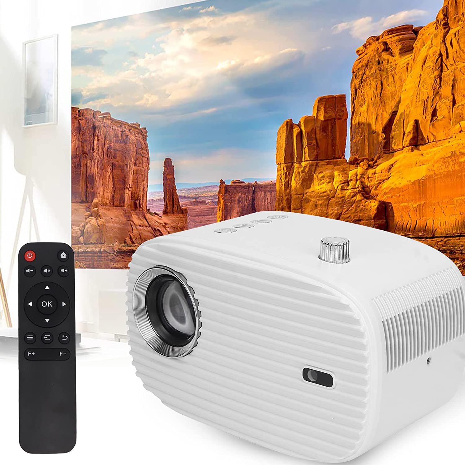 Un proyector blanco con un control remoto, proyectando un paisaje en una pared.