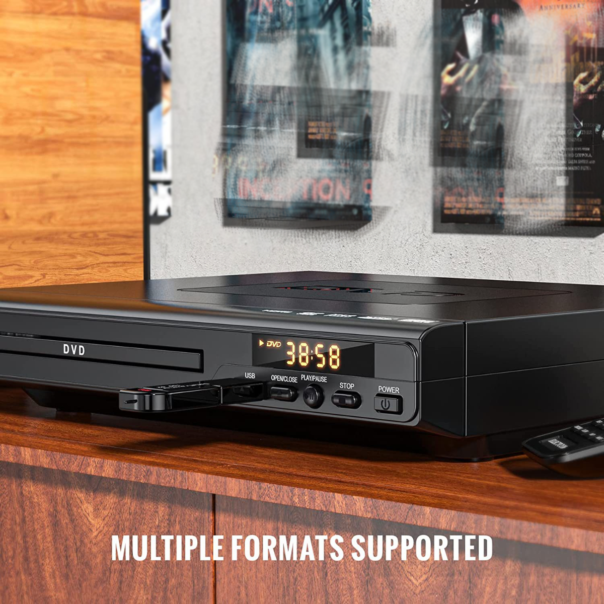Reproductor de DVD en una superficie de madera, con una memoria USB insertada. Soporta múltiples formatos, con botones de control.