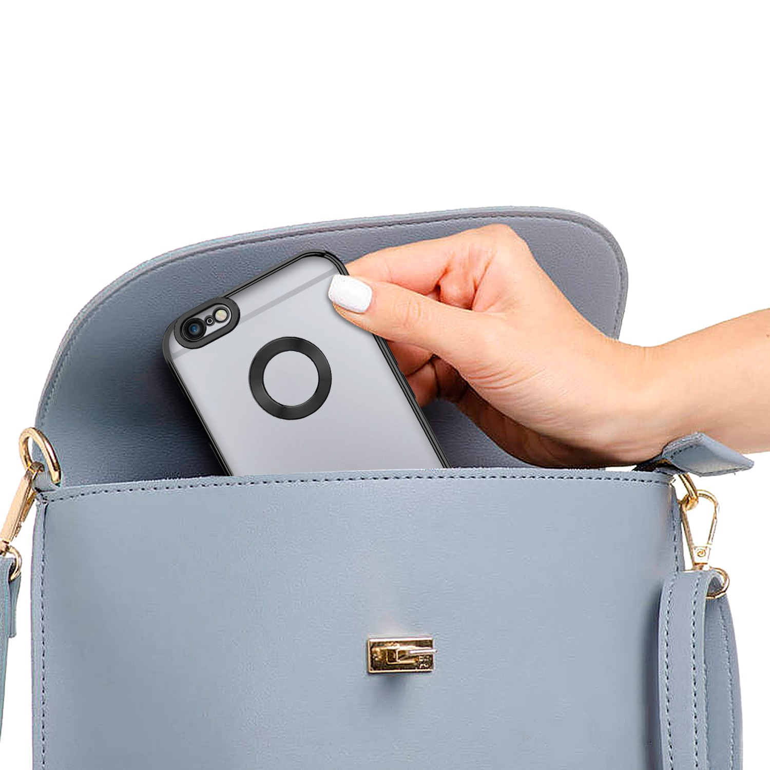 Eine Hand, die ein graues Telefon in eine hellblaue Handtasche legt.