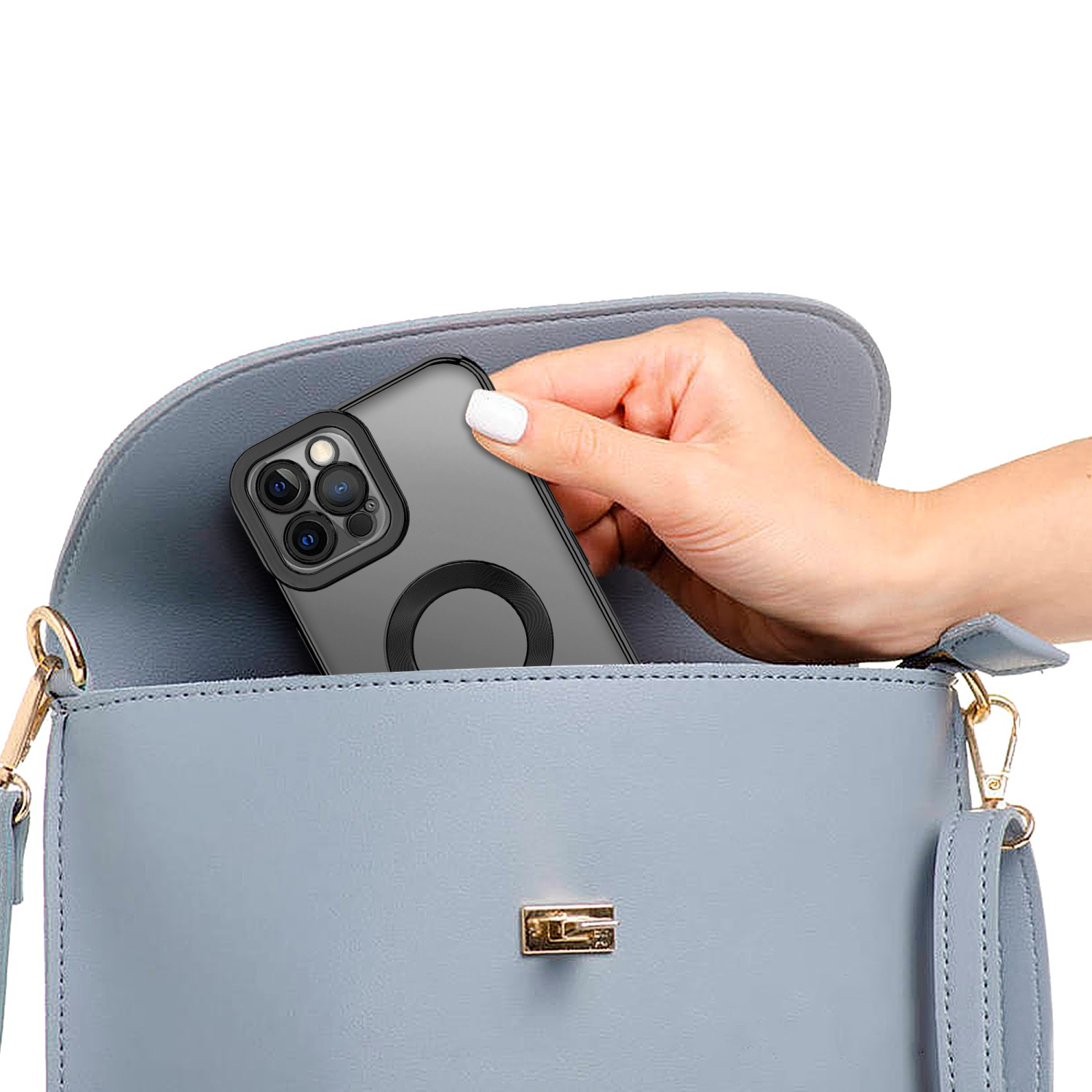 Hand legt ein Telefon in eine hellblaue Handtasche. Das Telefon hat eine schwarze Hülle mit einem kreisförmigen Magneten.