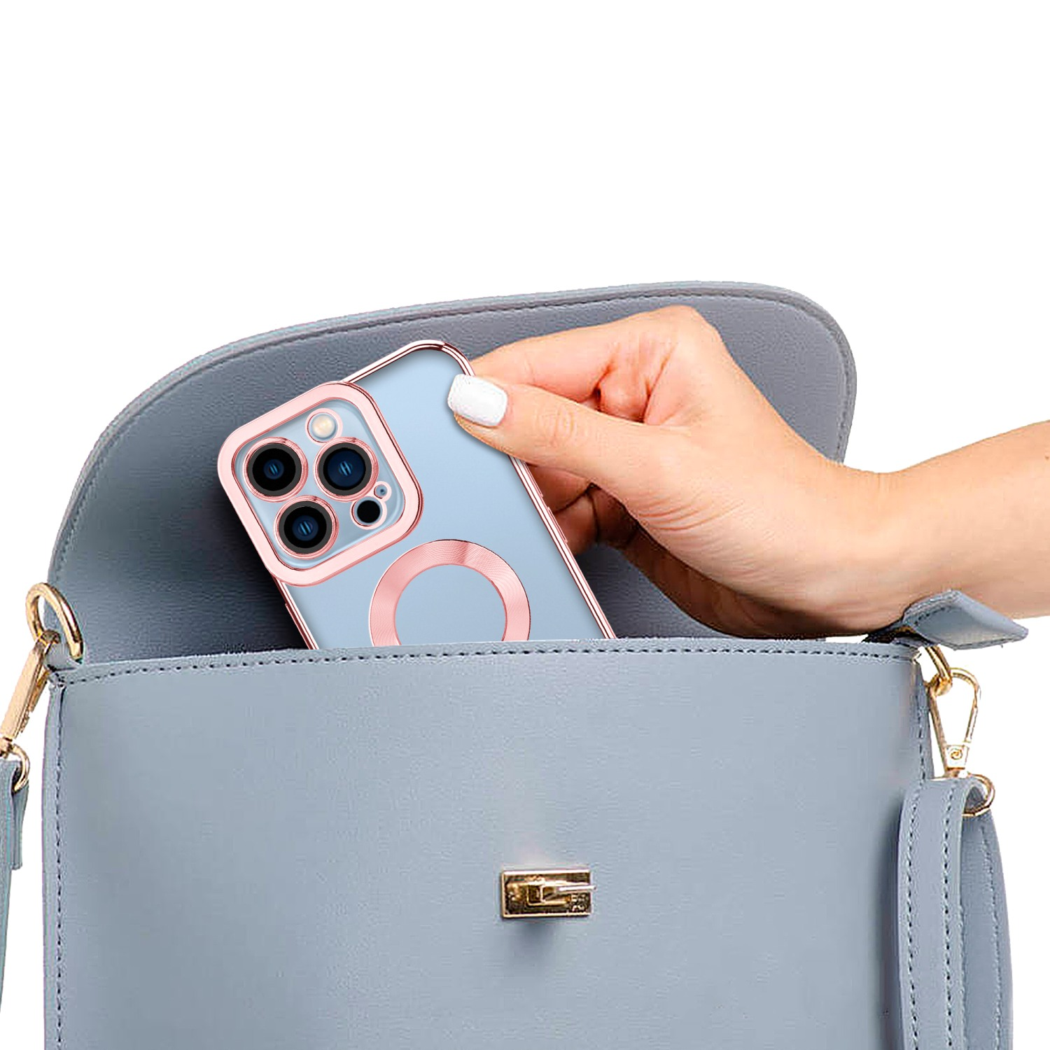 Eine Hand legt ein Telefon in eine graue Handtasche. Das Telefon hat einen goldenen Rand.