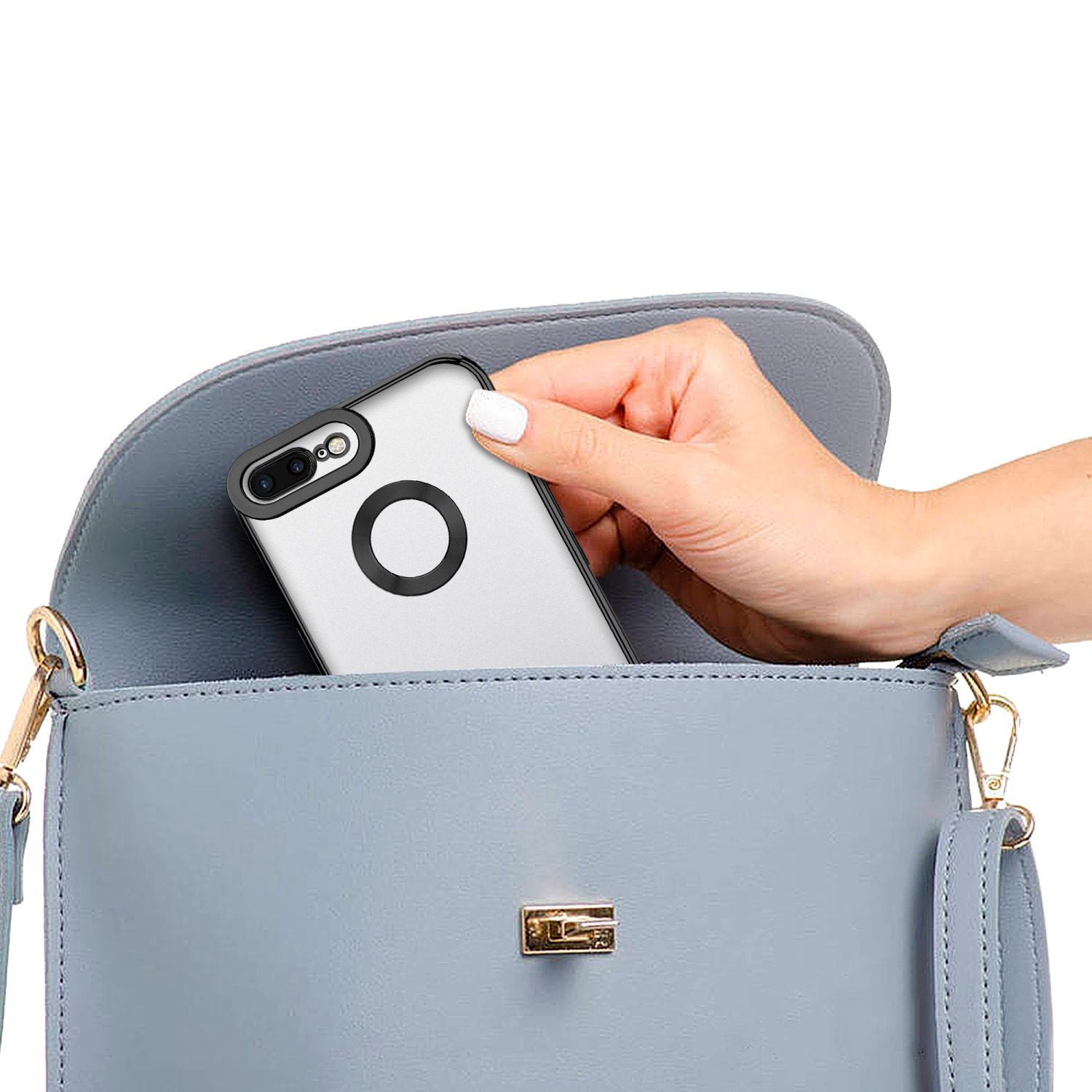 Eine Hand legt ein Handy in eine blaue Handtasche.