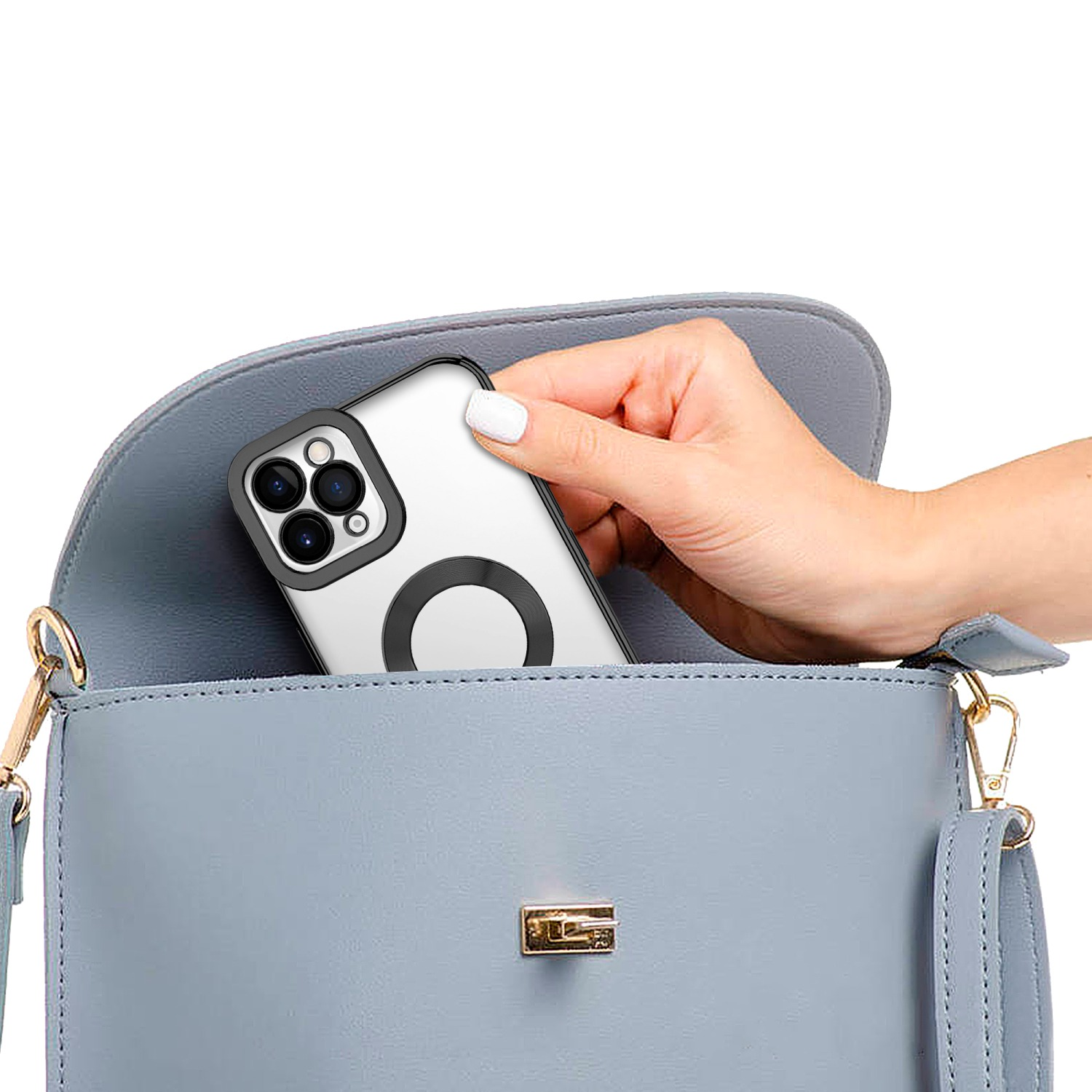 Eine Hand, die ein weißes Telefon mit Ringhalter in eine blaue Handtasche legt.