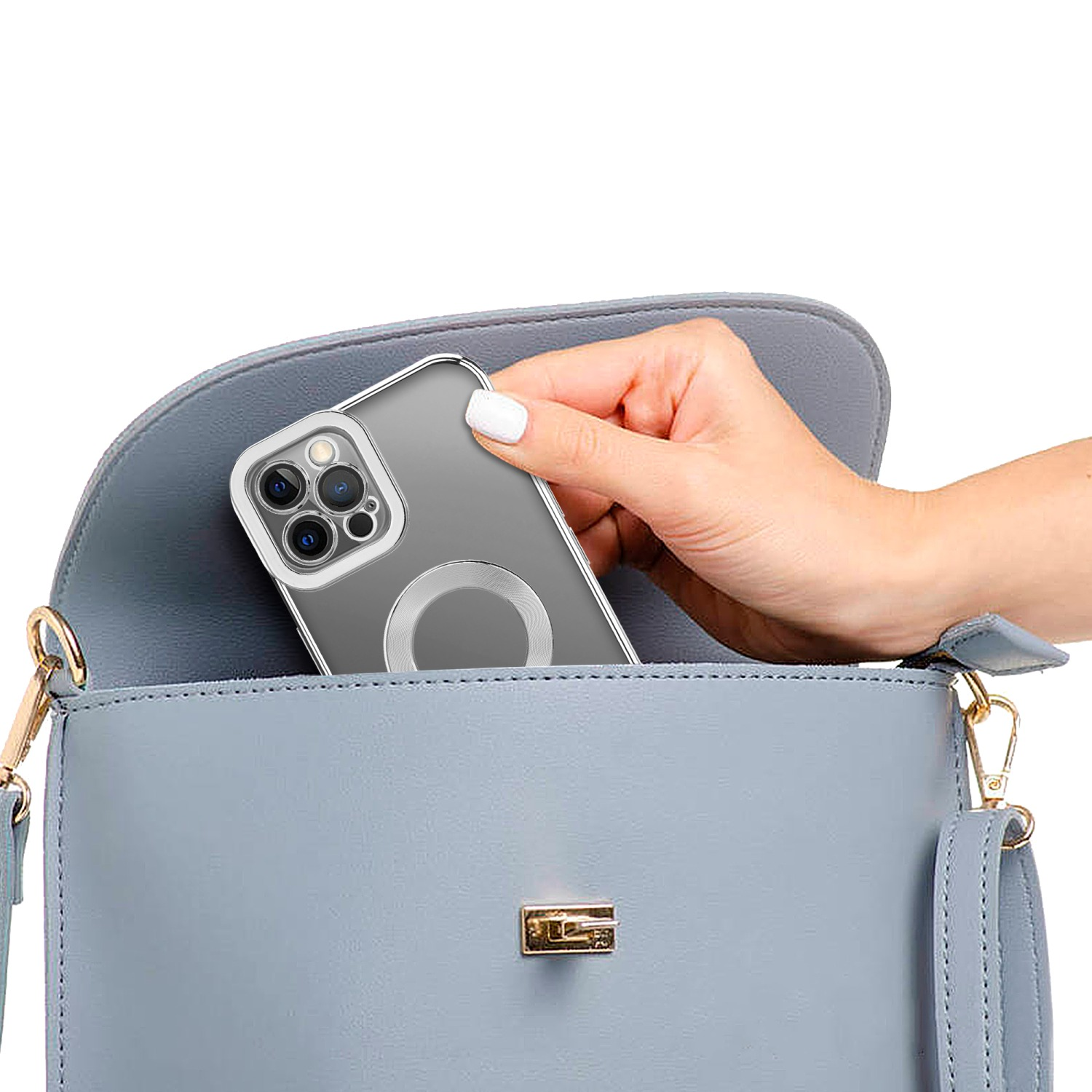 Eine Hand, die ein Telefon in eine hellblaue Handtasche legt.