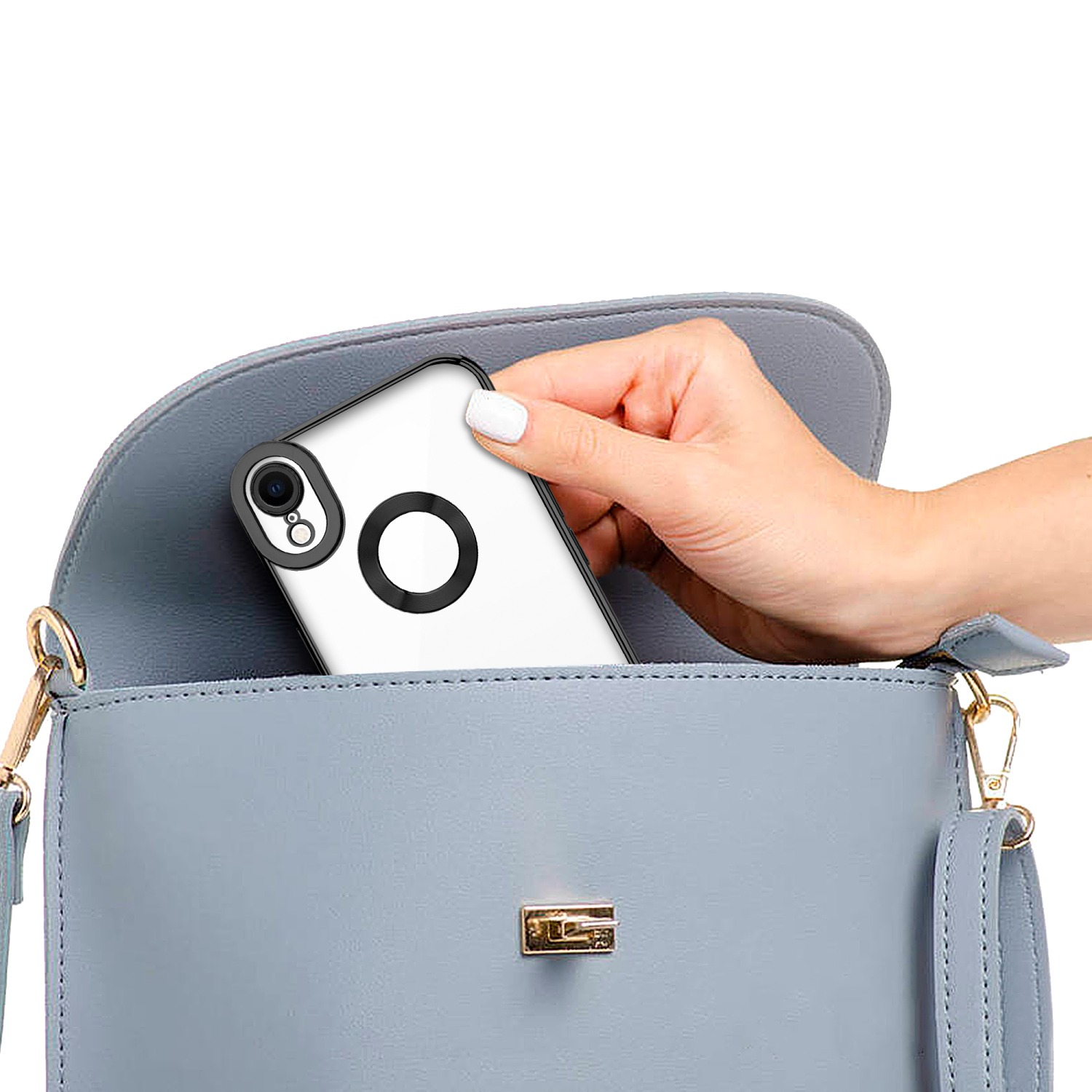 Mano che mette un telefono con una custodia trasparente in una borsa blu. Il telefono ha un anello nero.