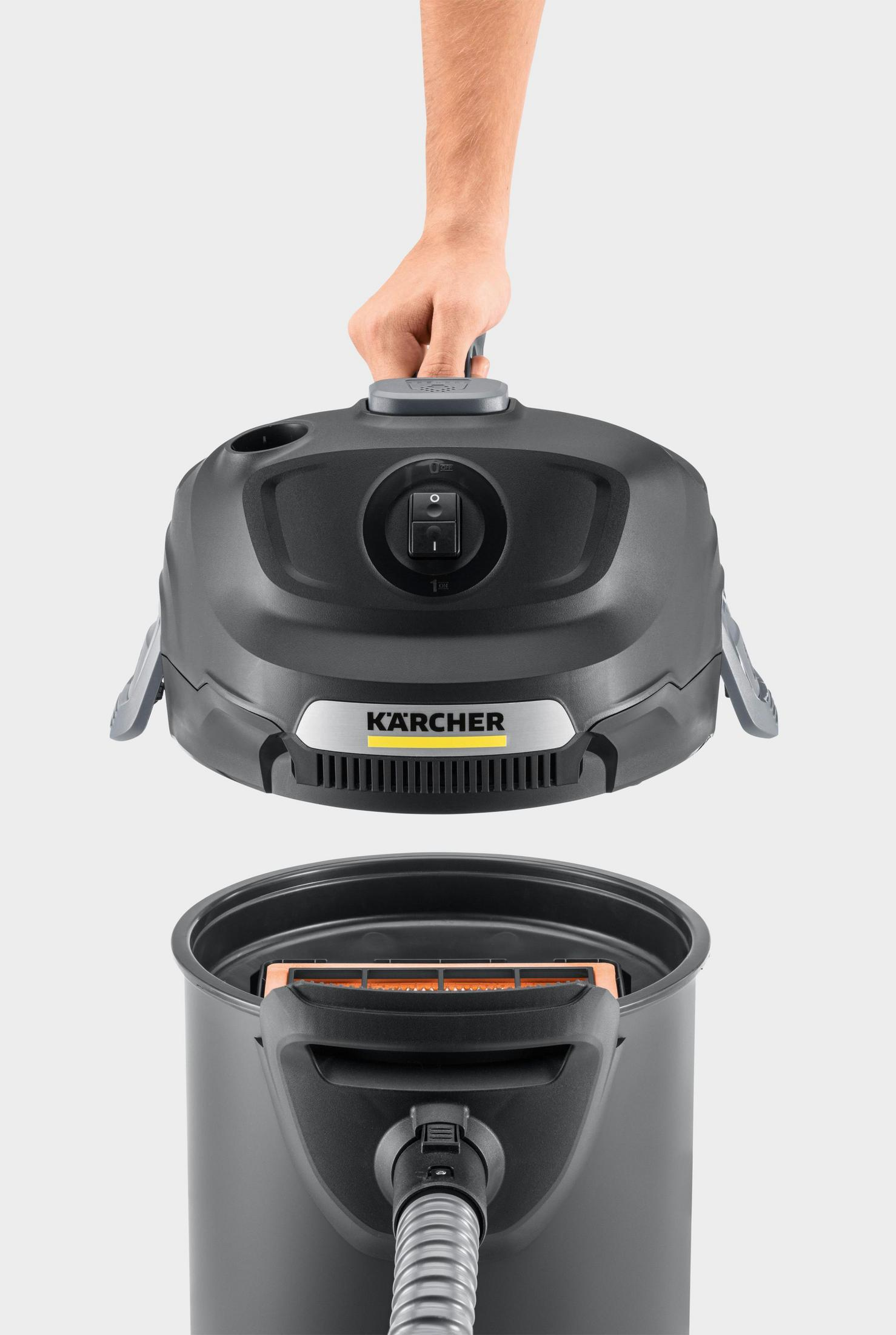 Górna część czarnego odkurzacza jest podnoszona. Dolna część jest poniżej. Marka to Kärcher.