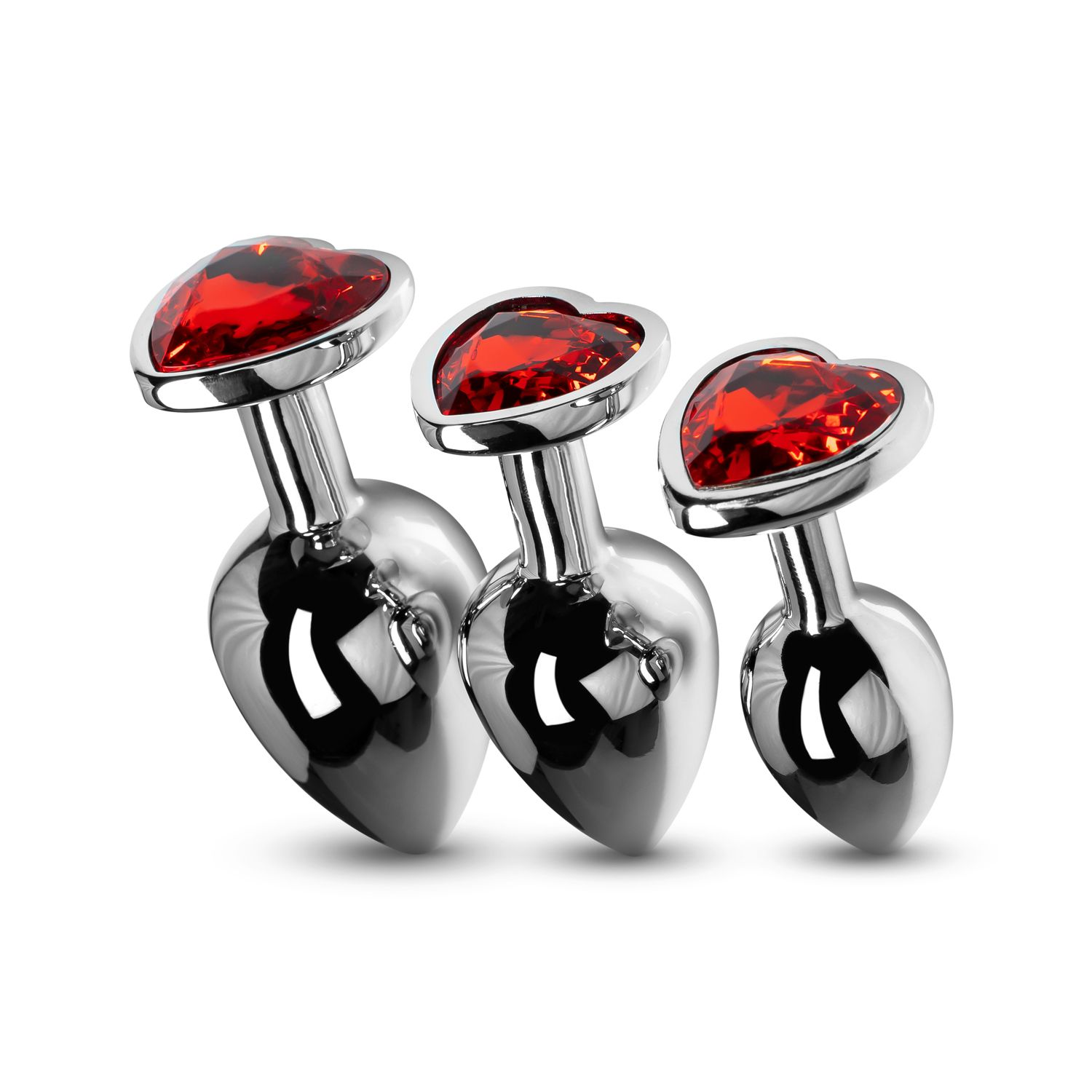 Drei Metall-Anus-Stecker mit roten herzförmigen Juwelen.