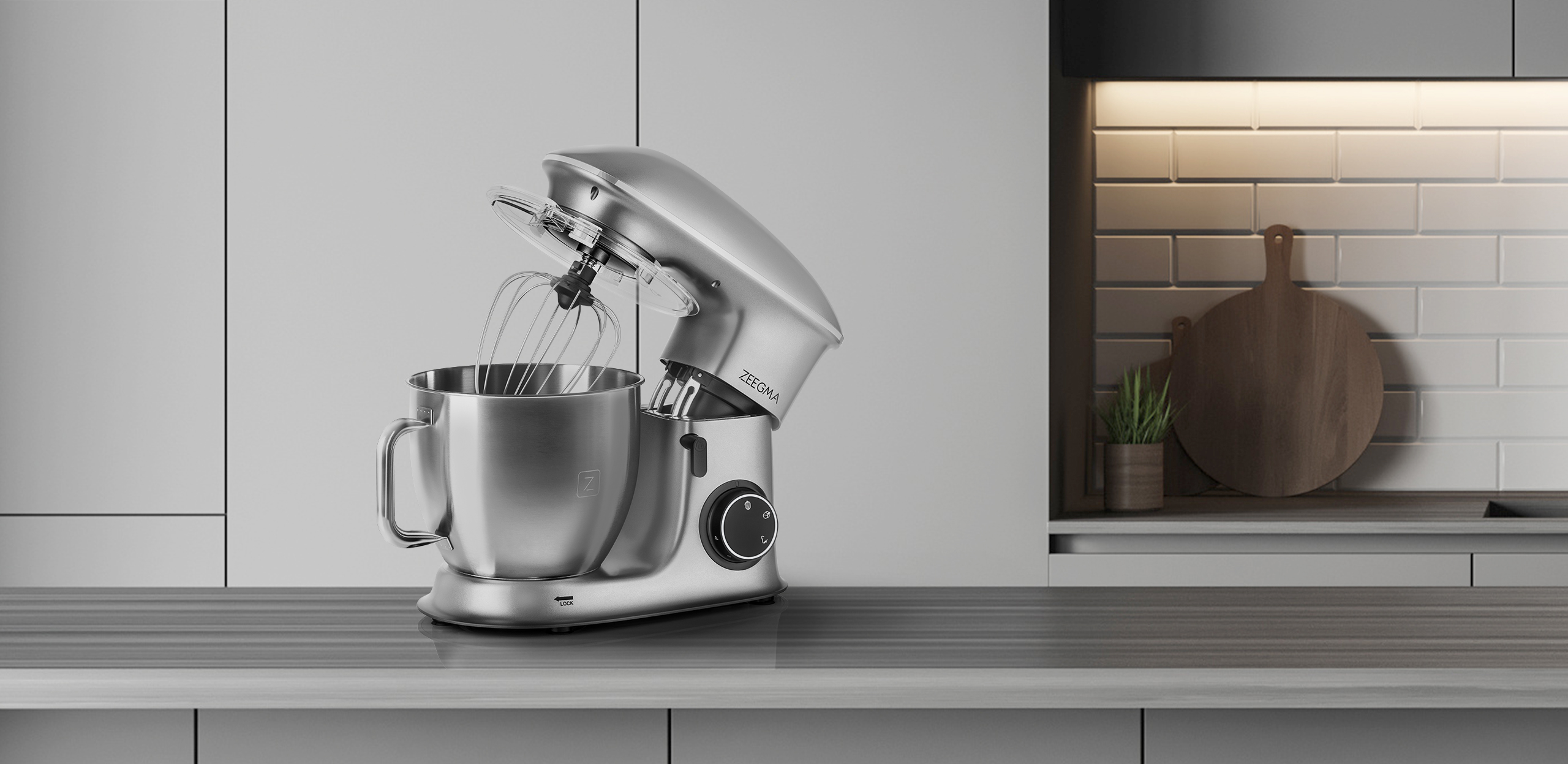 Srebrny mikser stojący z końcówką do ubijania, na blacie, z deską do krojenia w tle.