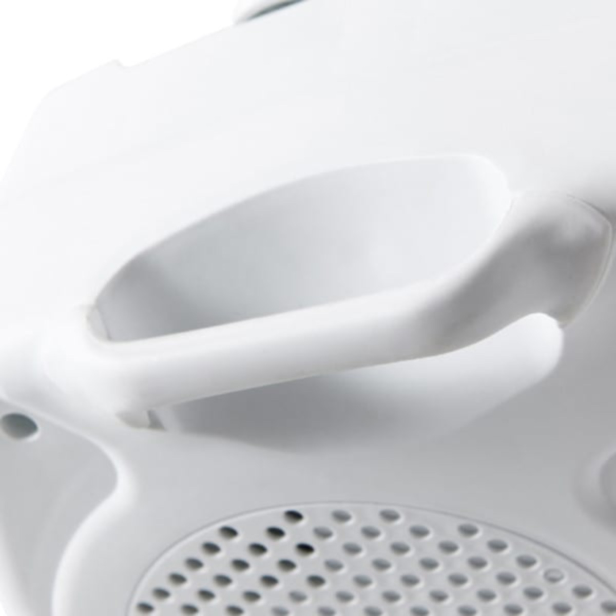 Primer plano de un asa blanca y una estructura tipo ventilación con agujeros pequeños.