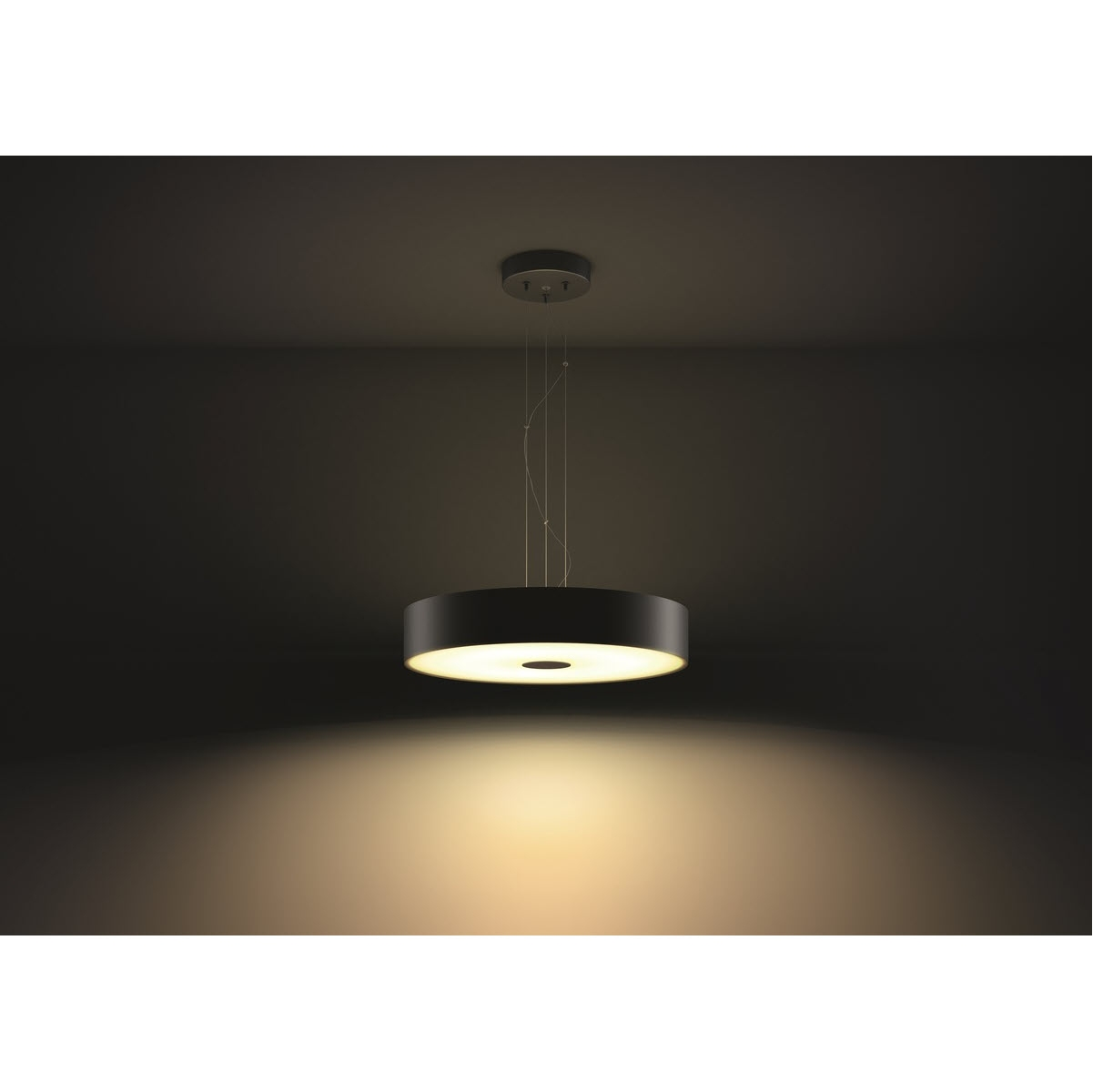 Moderne schwarze Pendelleuchte, die von der Decke hängt und unten einen warmen Schein wirft.