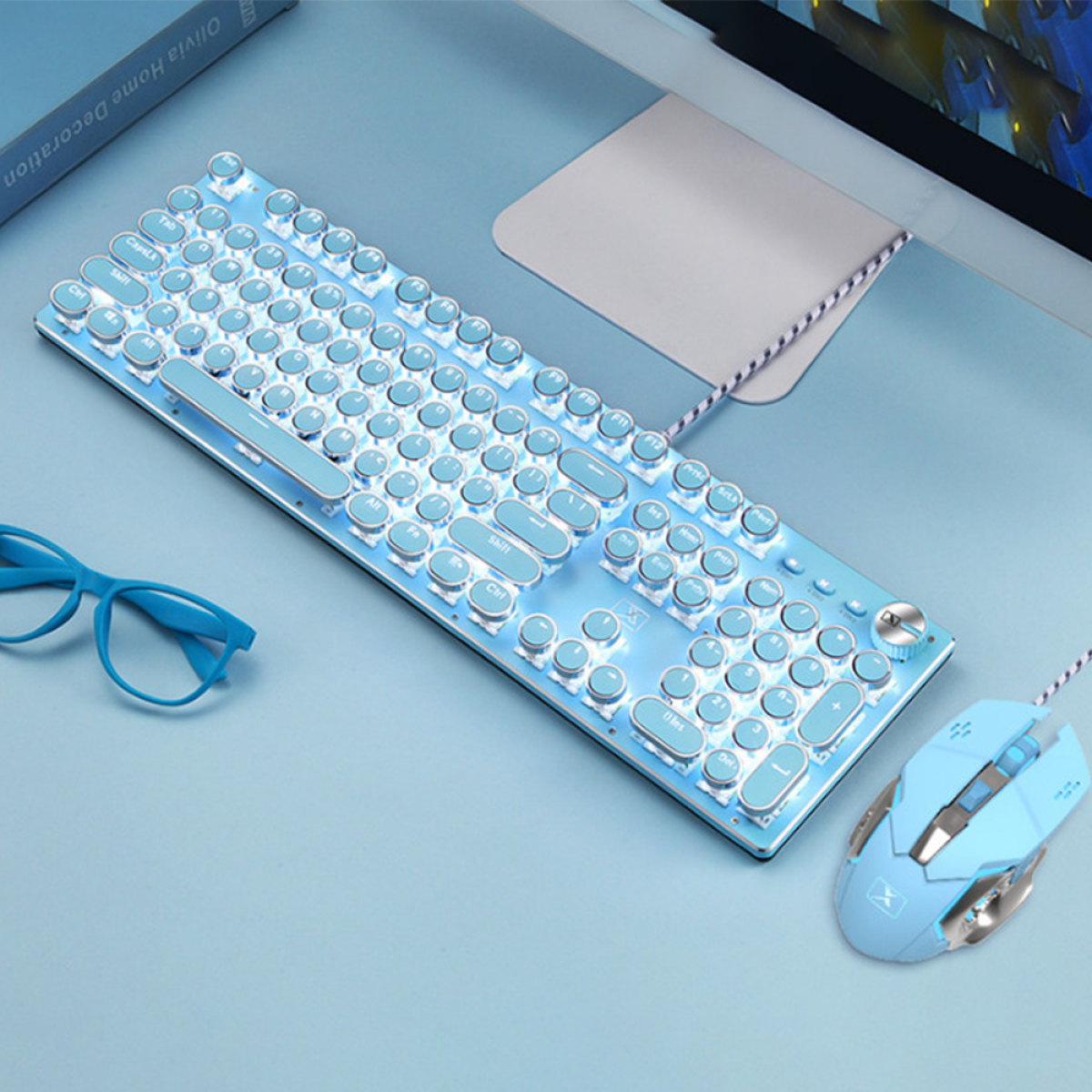 Blaue Retro-Tastatur und -Maus auf blauer Oberfläche, mit Brille und Buch.