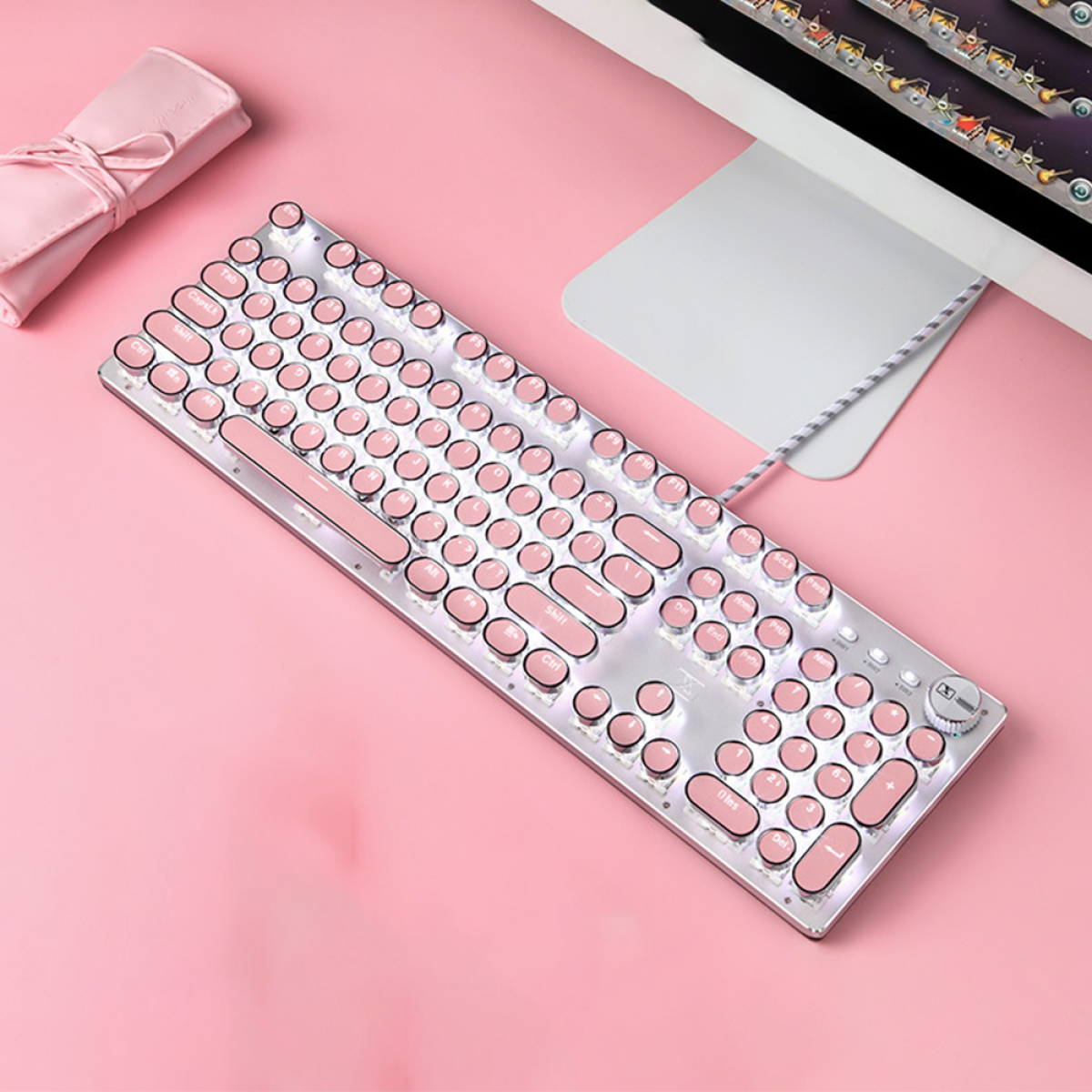 Eine rosa Tastatur mit rosa runden Tasten. Die Tastatur ist silberfarben. Rechts ist ein Kabel.
