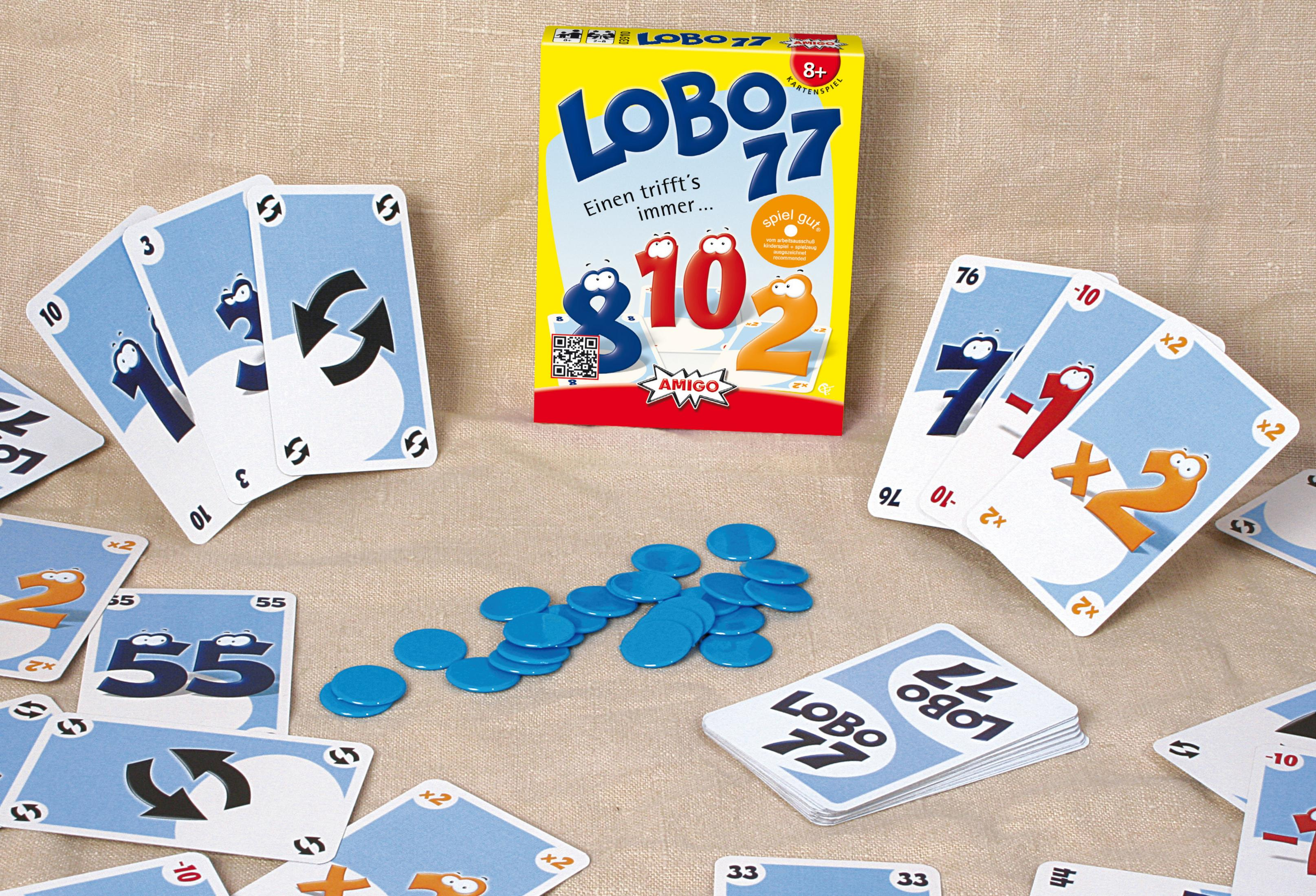 Lobo 77 Kartenspiel mit Karten und blauen Chips auf einer beigen Oberfläche verstreut.