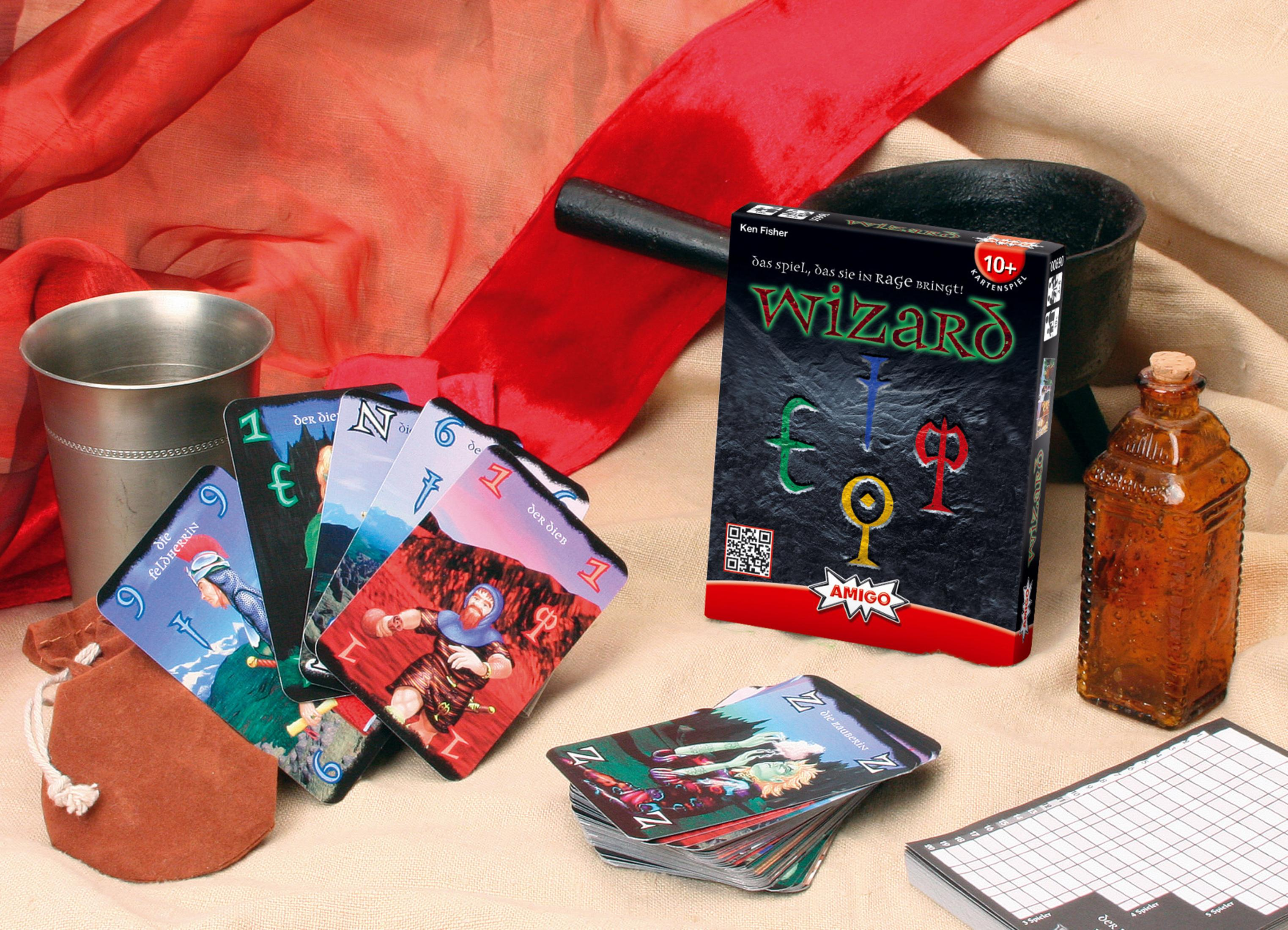 Gioco di carte Wizard con carte, un libro di regole e accessori su un panno rosso.