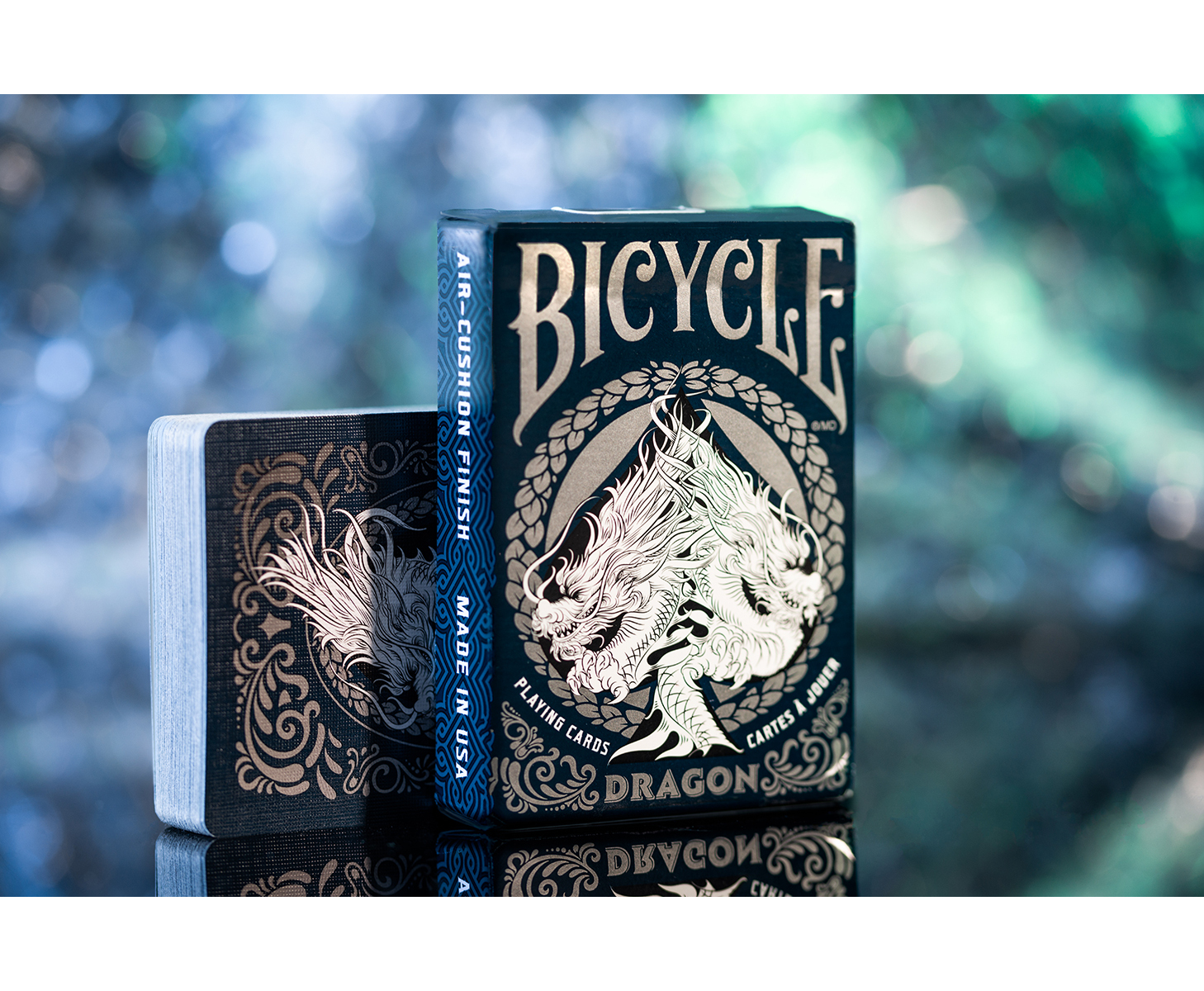 Zwei Bicycle Dragon Spielkarten-Decks auf einer Oberfläche. Die Decks sind schwarz mit goldenen Designs.