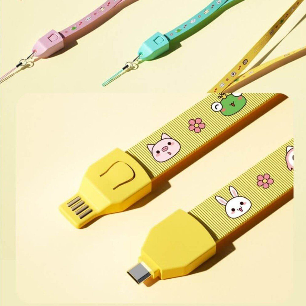 Cables USB coloridos con personajes de dibujos animados y conectores amarillos. Fondo claro.