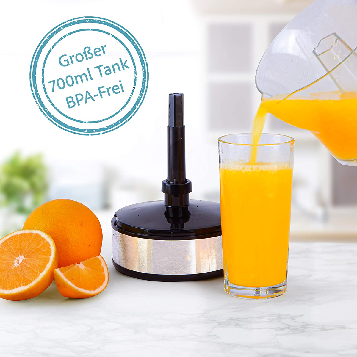 Saft gießt aus einem Krug in ein Glas, Orangen und eine Saftpresse.