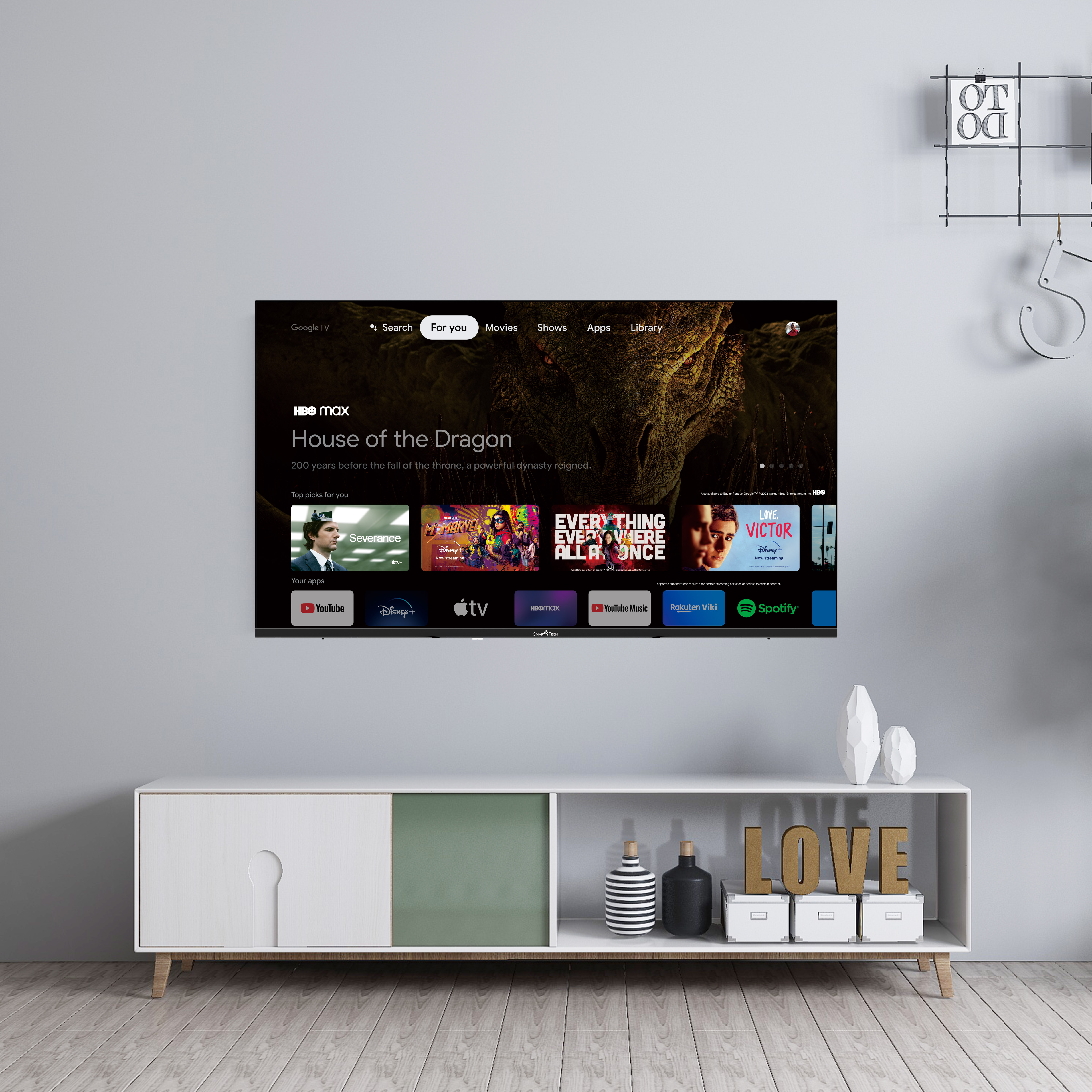 Una gran pantalla de TV que muestra HBO Max, sobre un gabinete blanco con decoración.
