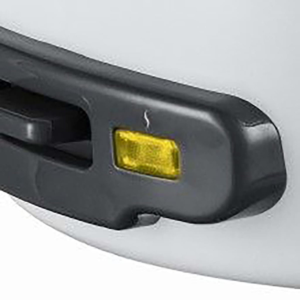 Żółte światło na czarnym obiekcie, białe tło.